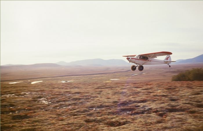 Me landing the cub at one of our mountain top camps. The flat top mountain you see in the background to the left is like the one I dropped Al and Steve off that overlooked the King Salmon River.