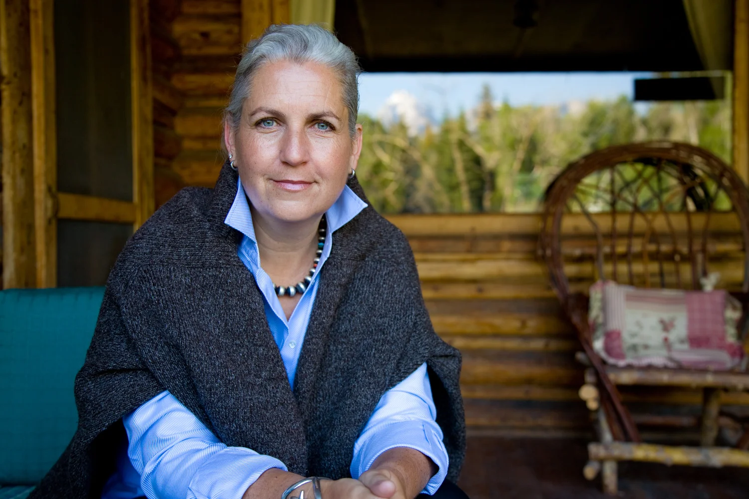  Portrait photography of woman against mountainside cabin background. Image by Susan Seubert 