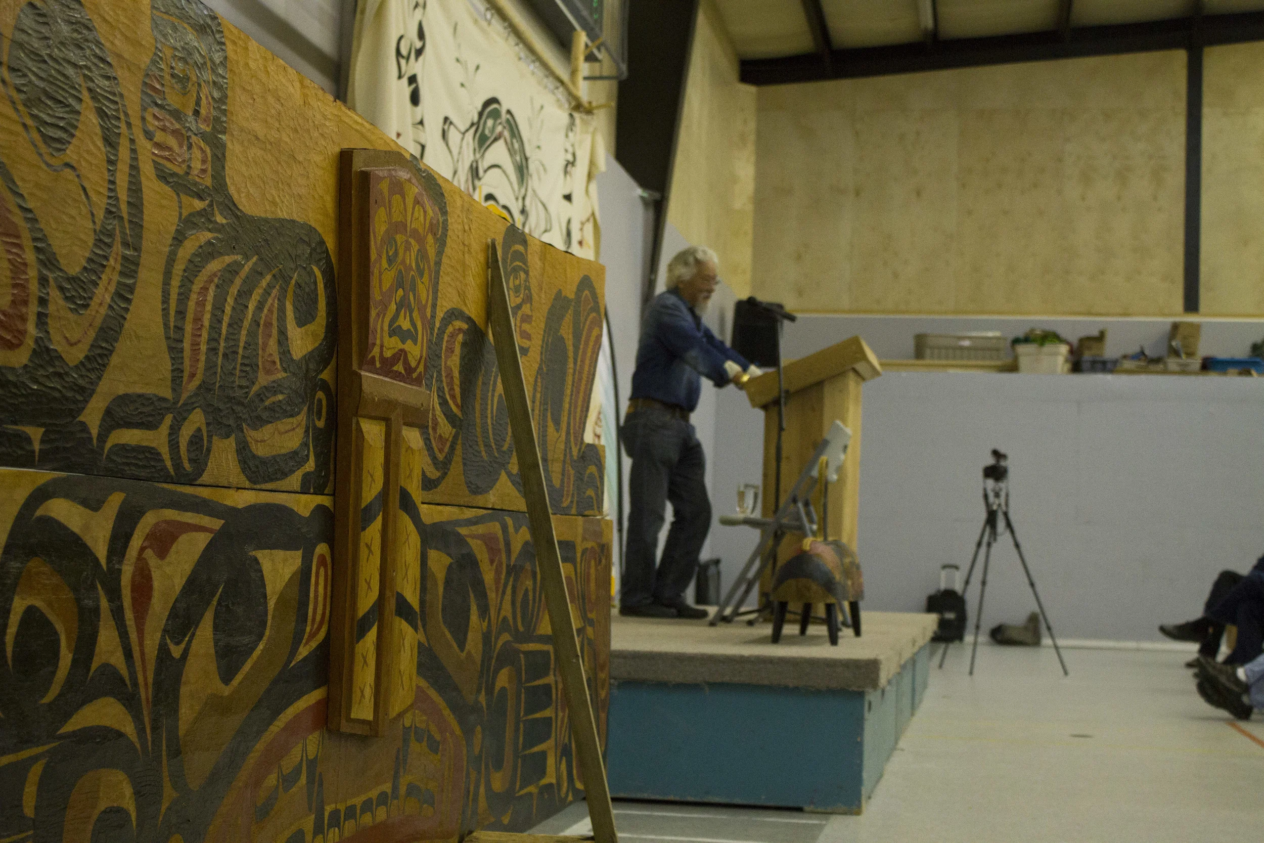 David Suzuki speaks on the Fort Rupert/Tsaxis reserve on northern Vancouver Island beside a carving of a traditional copper. © North Island Gazette. 