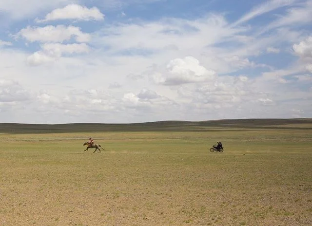 Family activities in Mongolia-9 year old Bujinlkham practices sprinting her horse in the steppes while her dad and sister follow behind. @aljazeera #mongolia #dundgovi #steppes #photojournalism #naadam