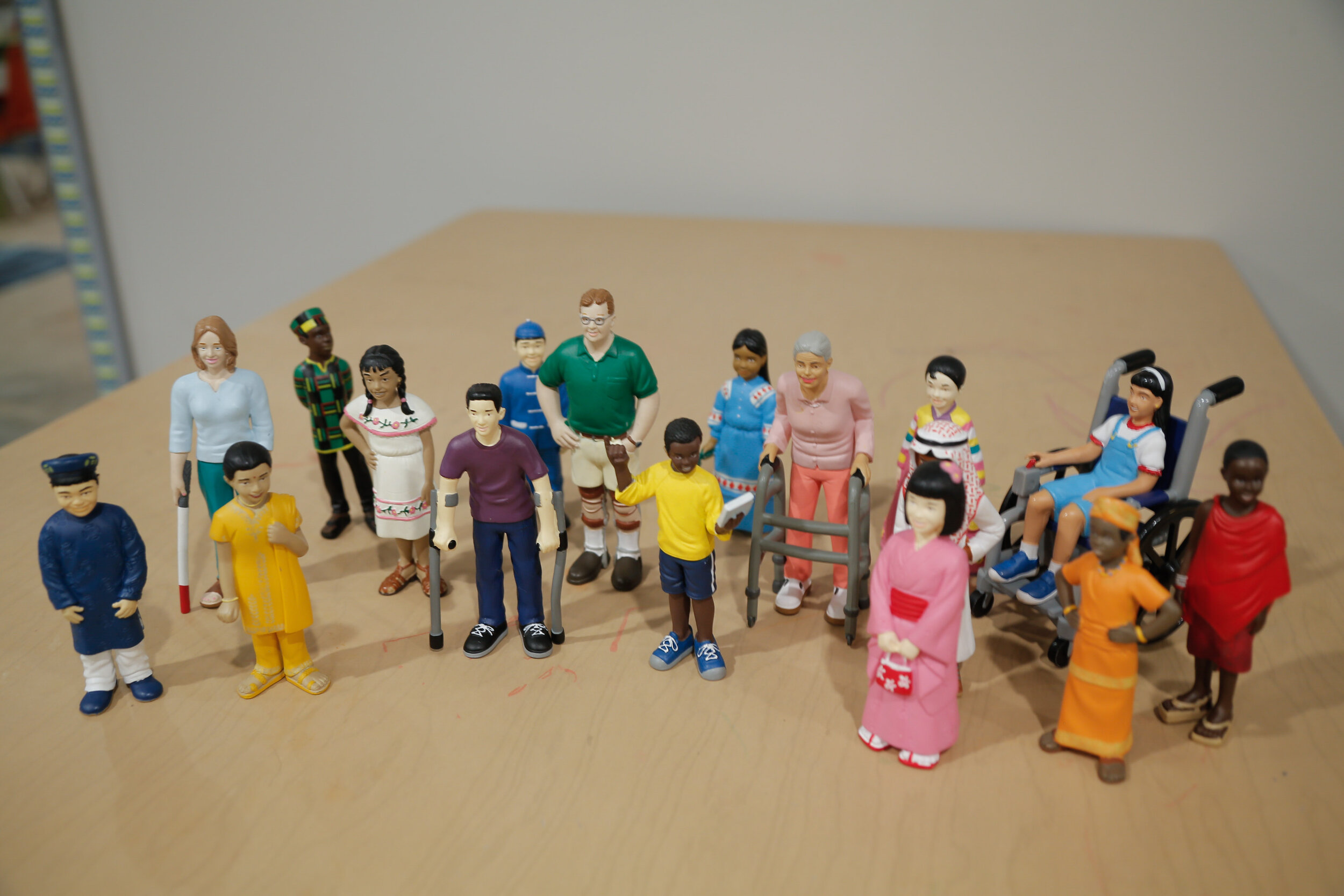  A variety of play dolls from different ethnicities some have mobility aids. 