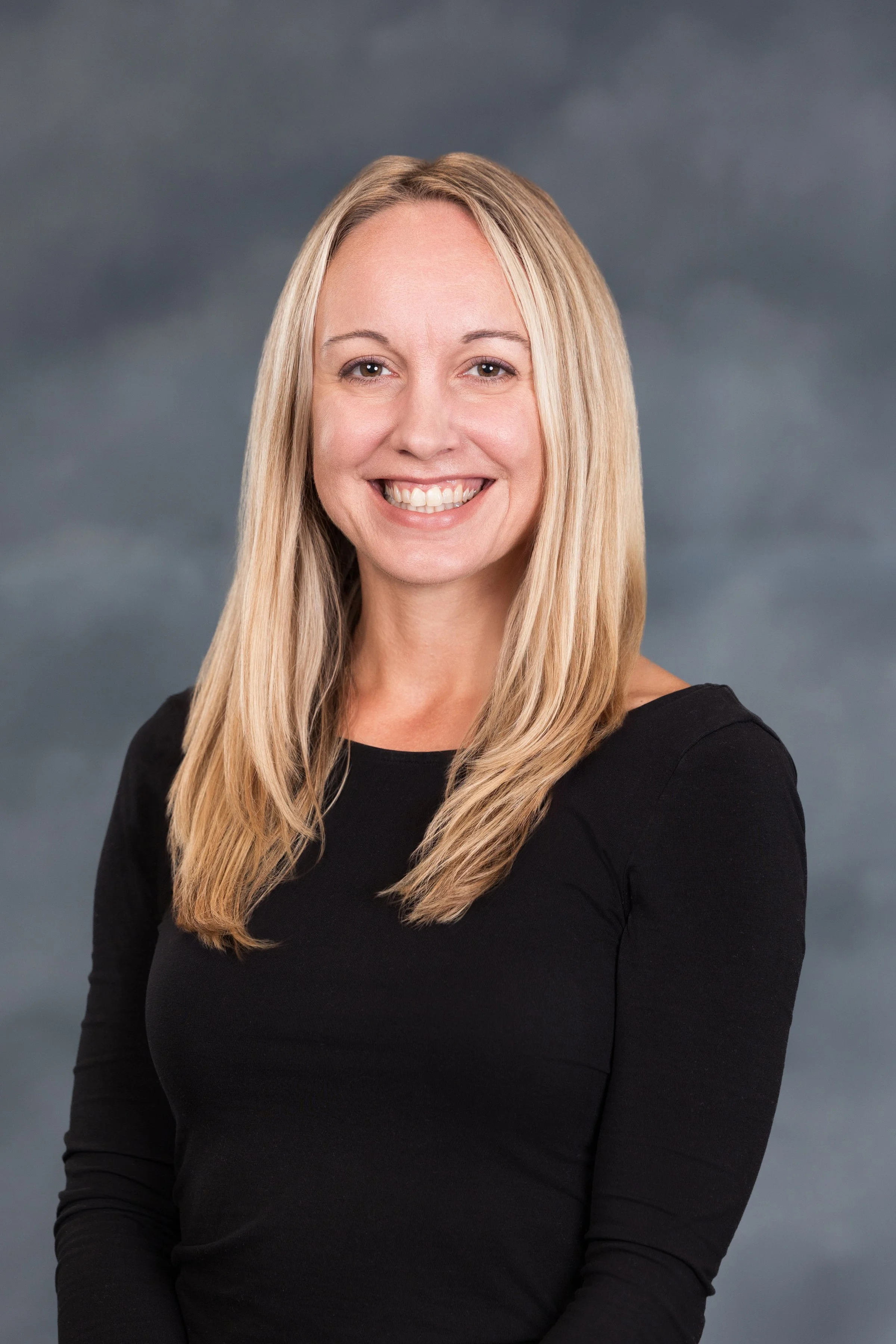 A professional woman blond in front of textured background