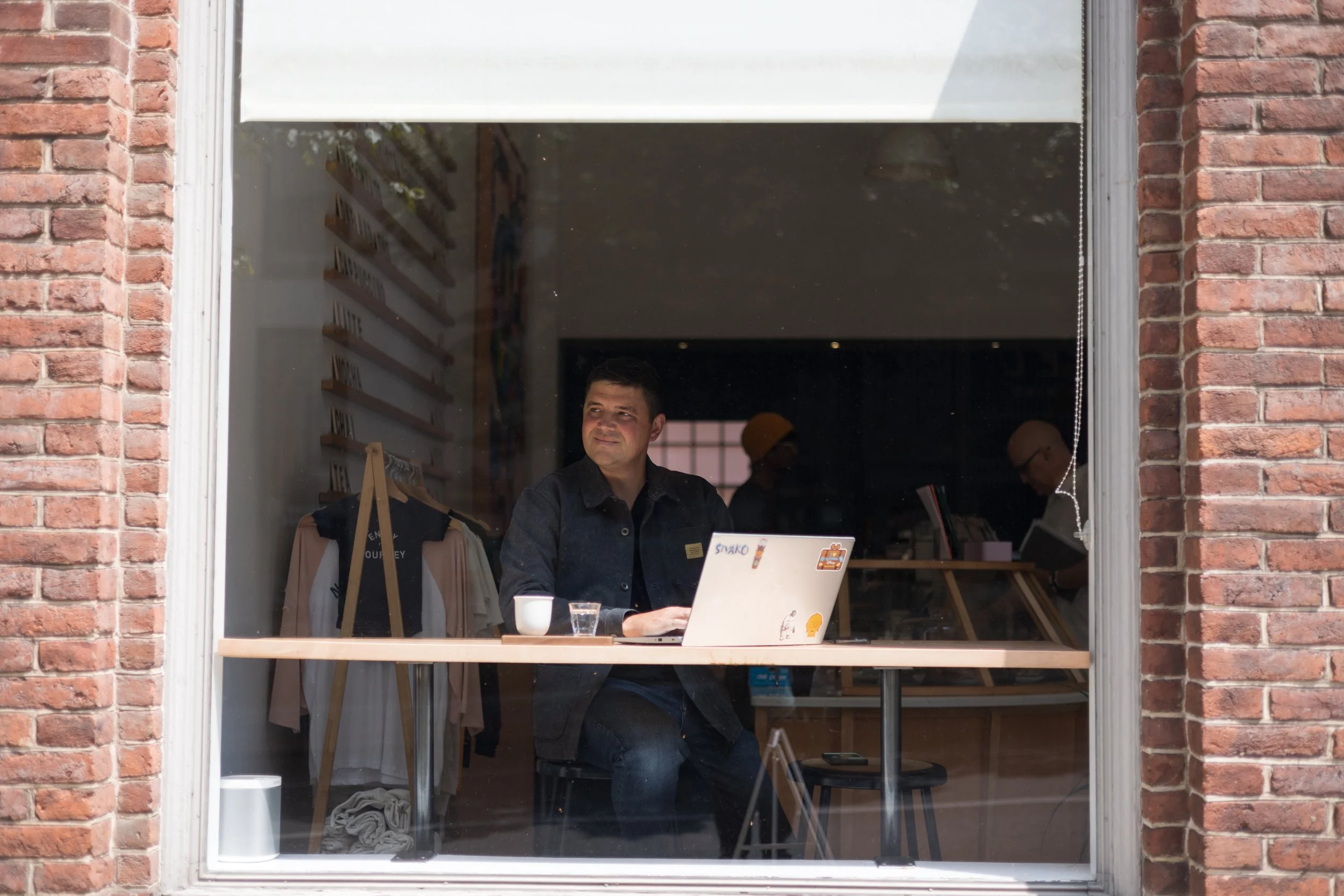 man working on laptop while looking out of window at Passenger Coffee