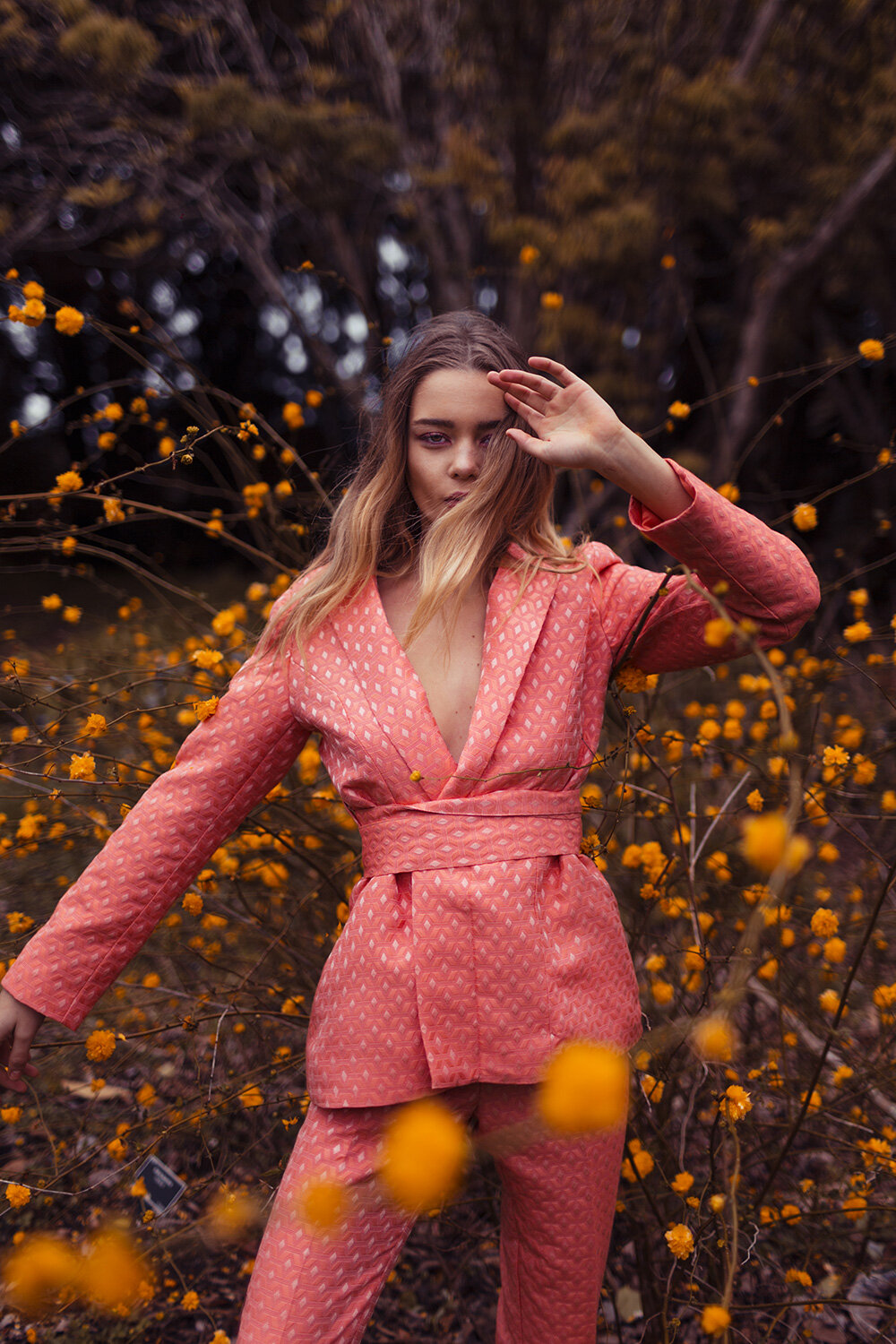  Fashion model amongst flowers in a power suit 