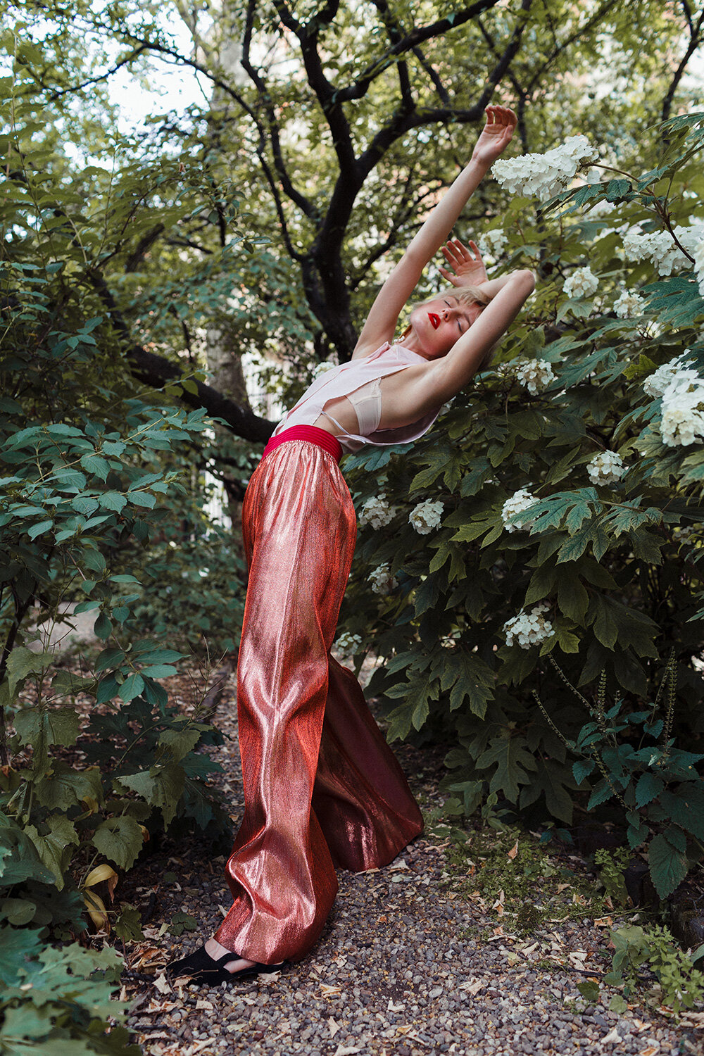  Fashion model stretching amongst flowers in Italy 