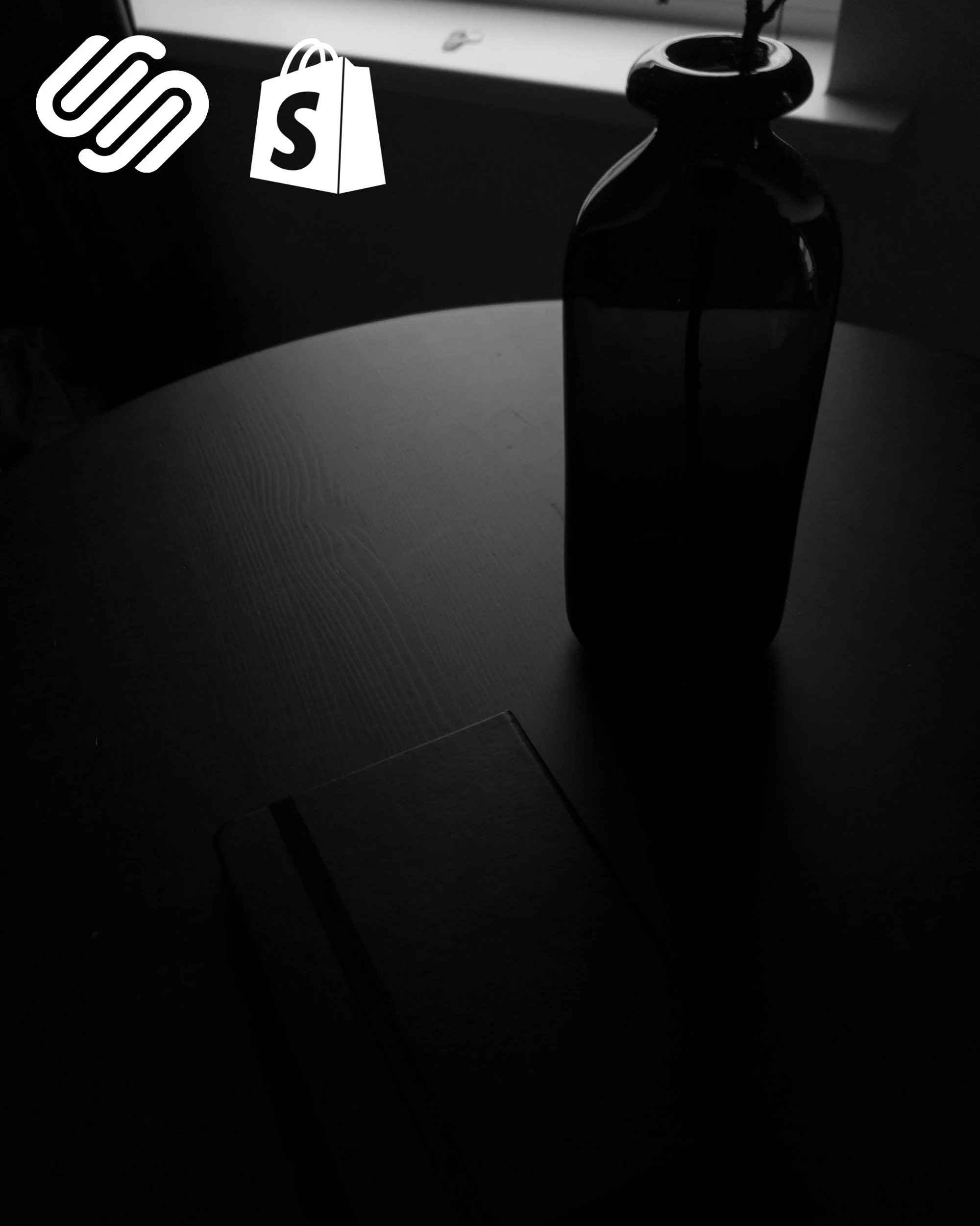 A dark silhouette of a closed bottle on a table in a dimly lit room, with a window in the background and a few decorative items on the table, creating a moody atmosphere.