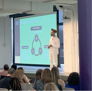 Omari speaking on stage about Squarespace business and digital products