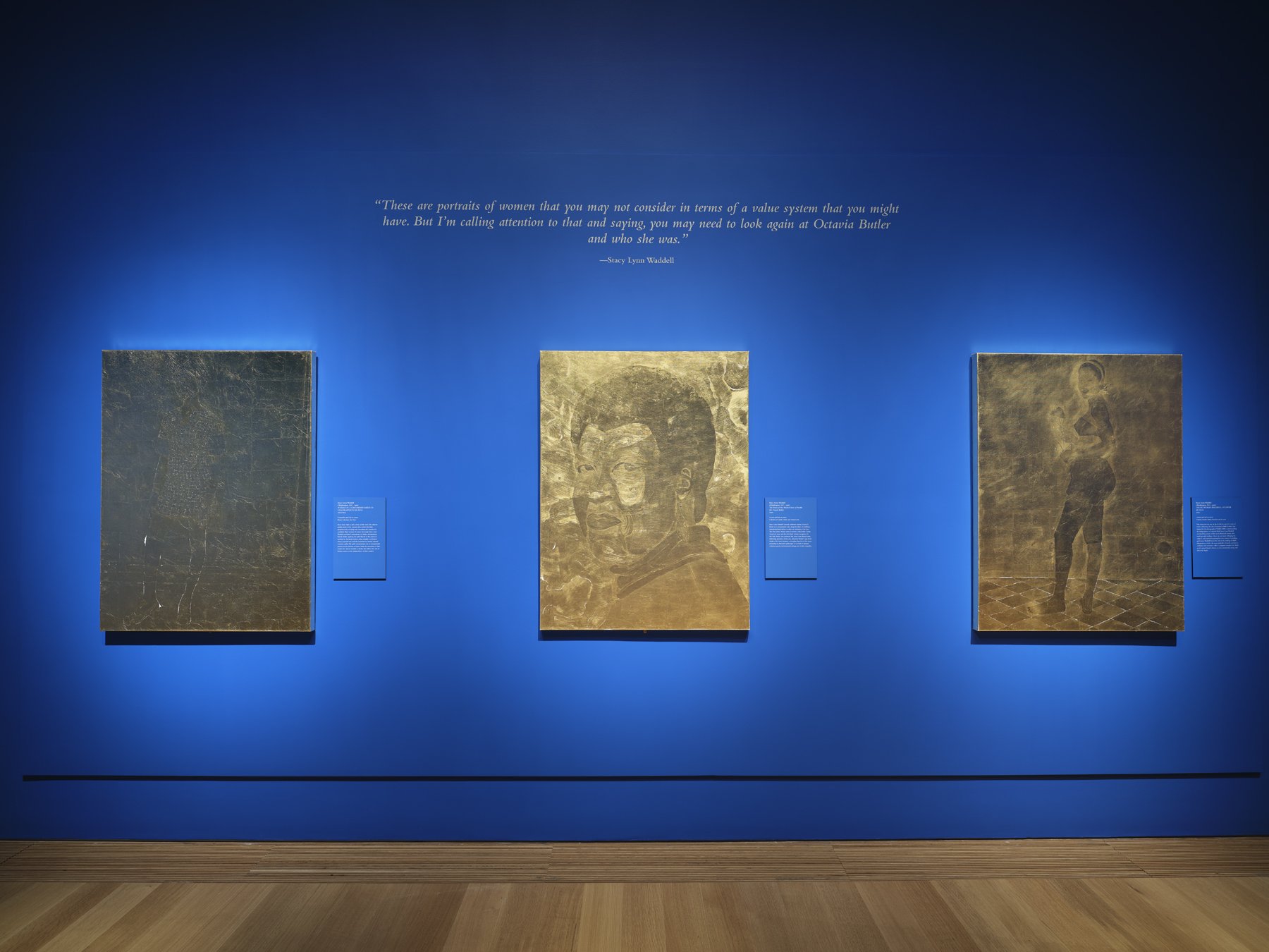   (from left to right)  WOMAN IN A CHECKERED DRESS IN CONTRAPPOSTO (for M. S.),  1971/2021, composition gold leaf on canvas, 48 x 36 inches;  The Dawn of our Kindred Sower of Parable (for Octavia E. Butler),  2020, 22-karat gold leaf on canvas, 48 x 