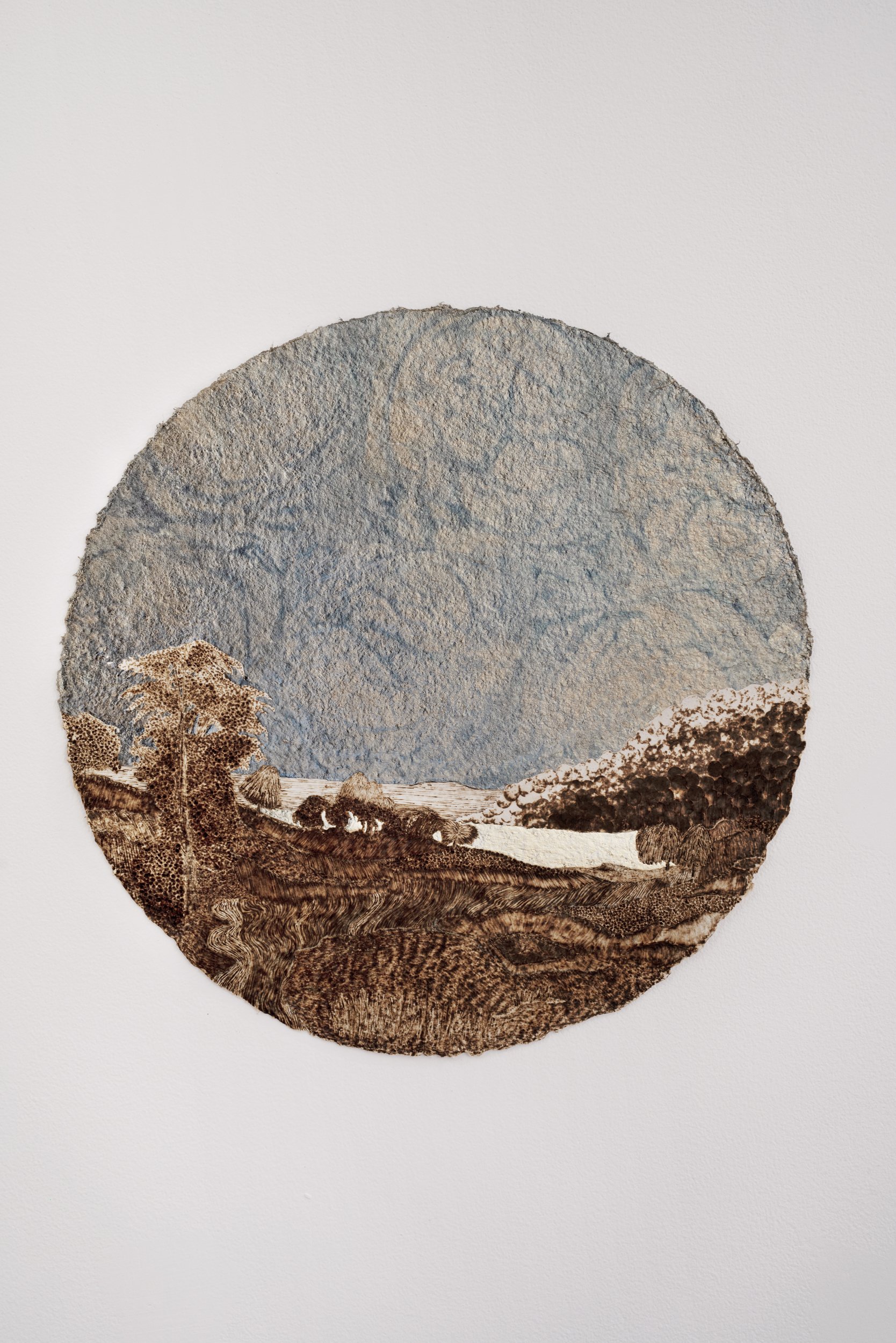   Landscape with Rainbow under Moonlight at Midnight (for R. S. D.),  1859/2021, burned handmade paper with blue pencil, variegated metal and composition gold leaf, 16 inches in diameter 