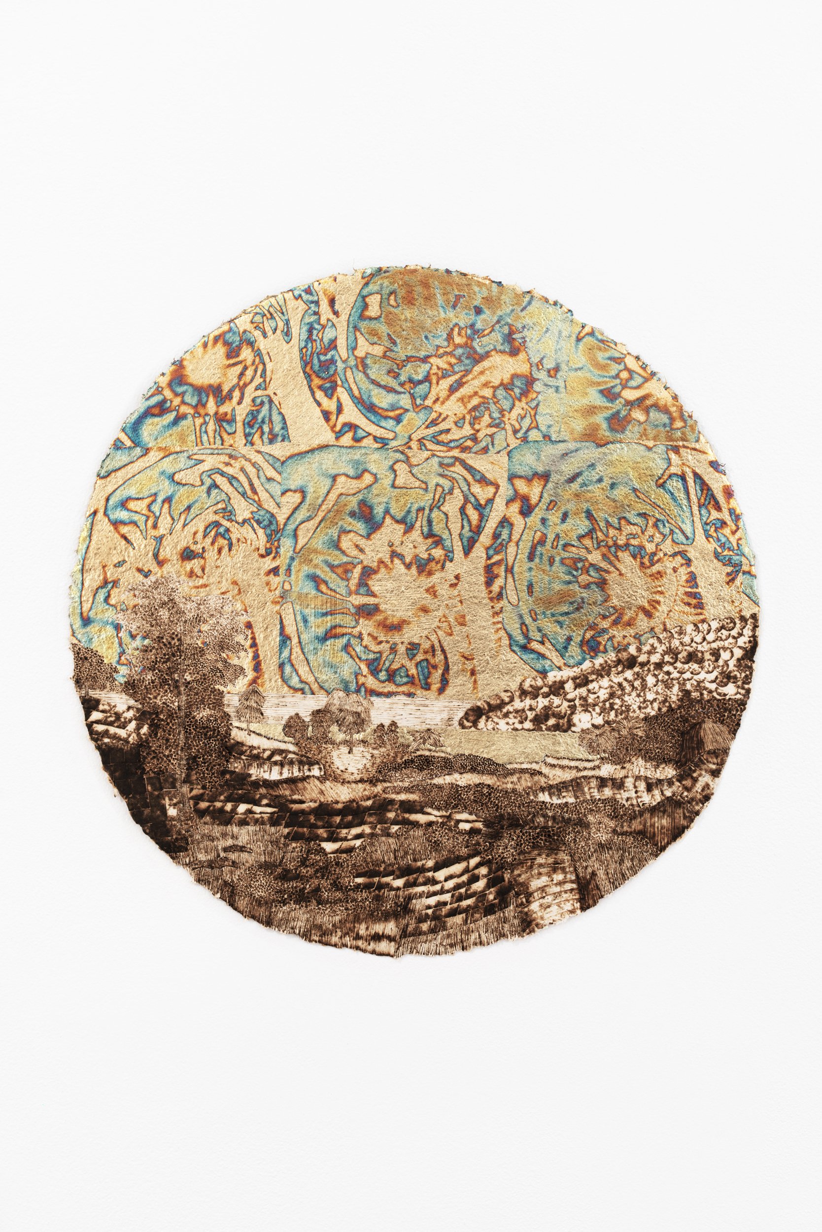   Landscape with Rainbow Sky at Sunset (for R. S. D.),  1859/2022, burned handmade paper with blue pencil, variegated metal and composition gold leaf, 16 inches in diameter 