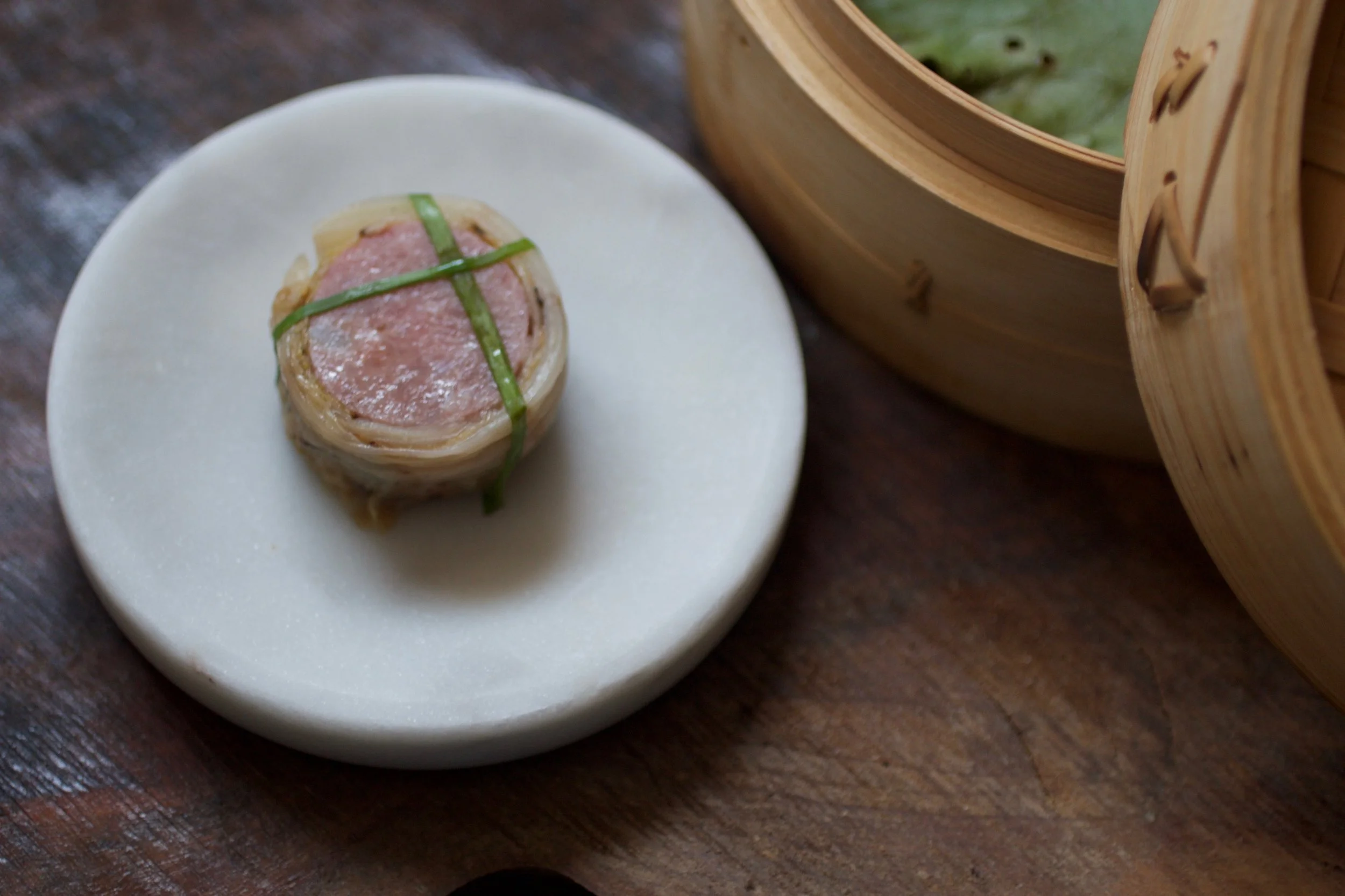MANIACALLY CRAFTED Pork and scallop sausage is served with carefully charred white kimchi.