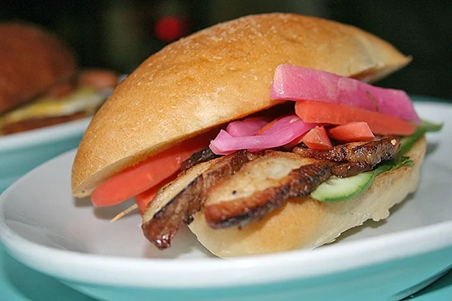 SPICE IS NICE Café Fiero’s bahn mi has serious spicy staying power. Made with braised pork belly, cucumber, mint, cilantro, house pickled carrots, daikon, serrano peppers, and sriracha mayo on a pan d’oro Cubano roll, this feast sets you back just $8.