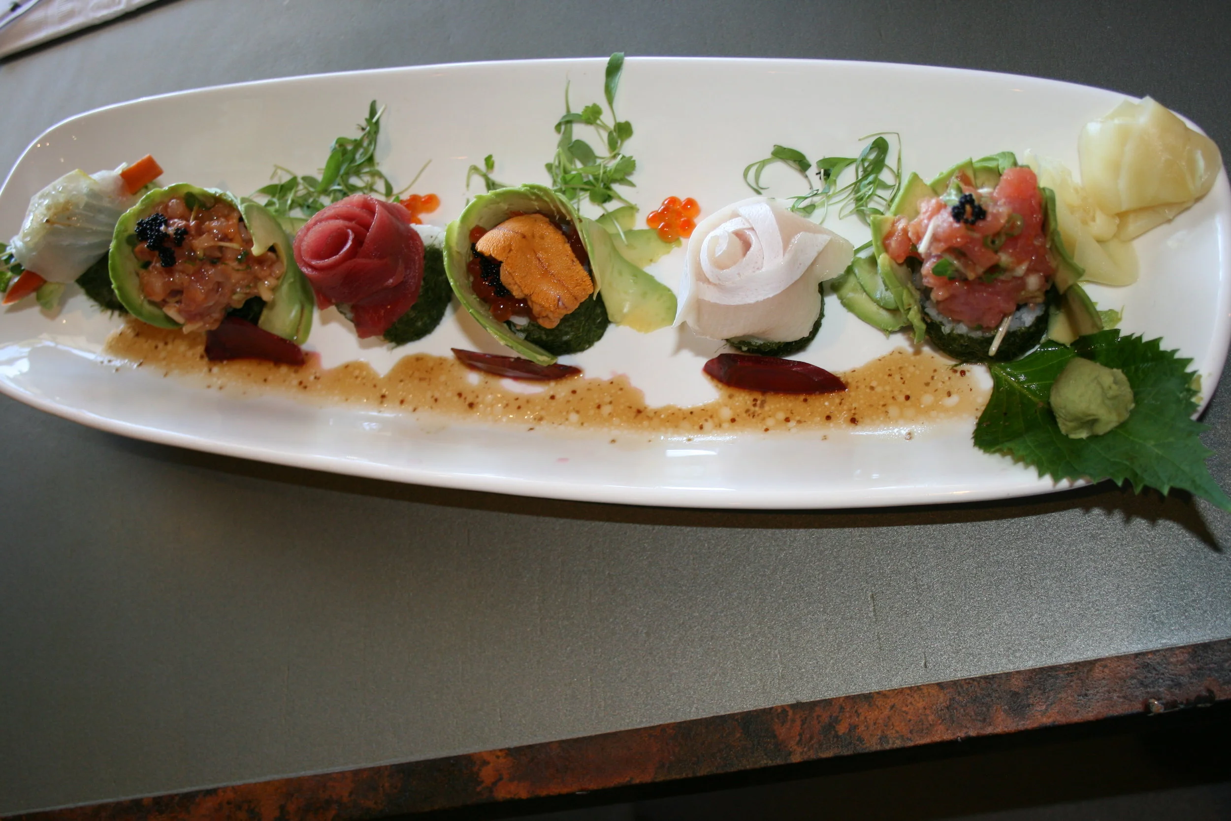 PACFIC DREAM Arigato Sushi's impressive Pacific Street roll features spicy tuna and cucumber within, plus a healthy helping of tuna, yellowtail, halibut, ikura (salmon roe), uni, and avocado throughout.