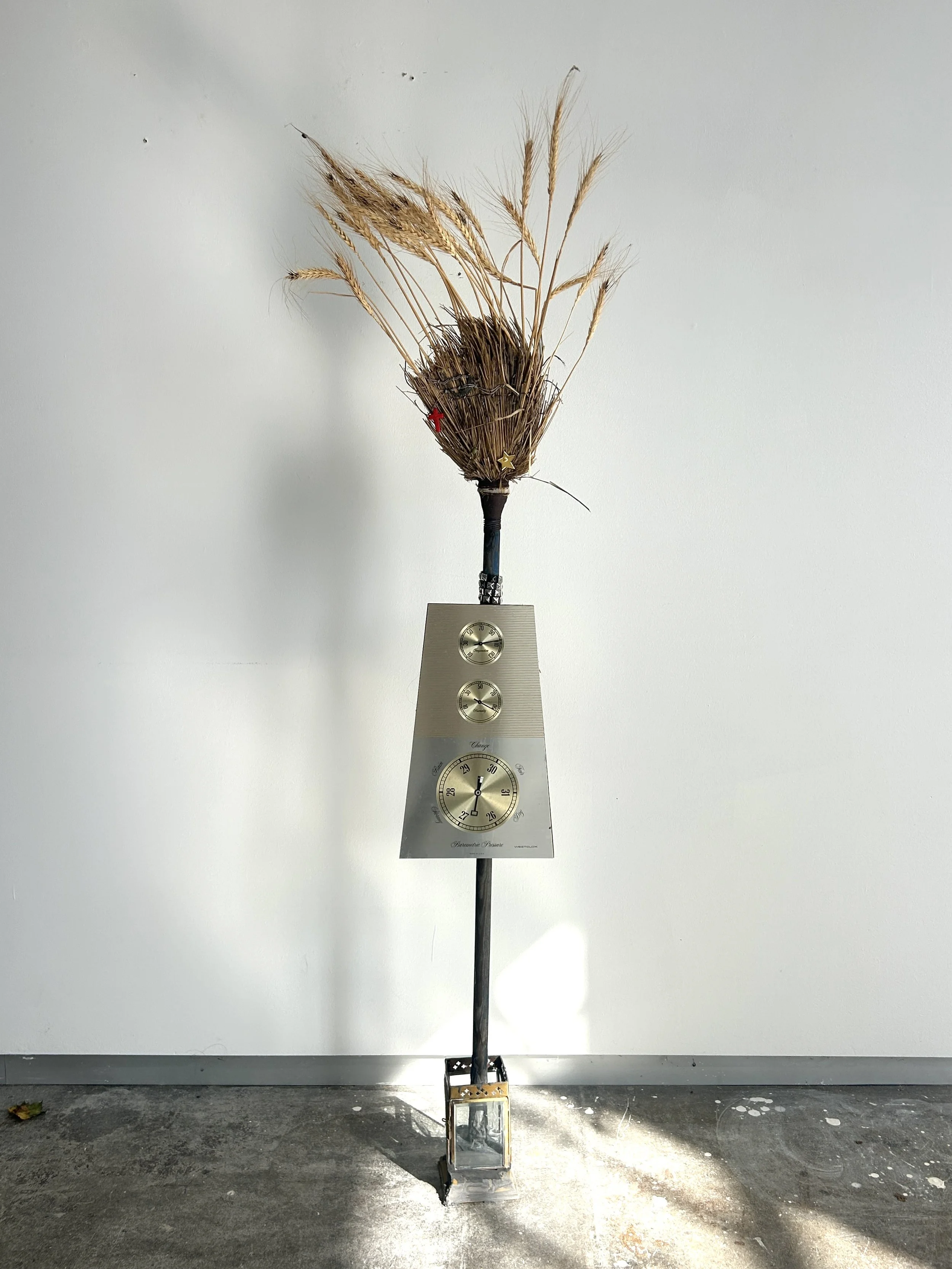 Ergot Apopheny Scapegoat, 2025, broom, rye, charms, cement, lantern, barometer, thermometer 