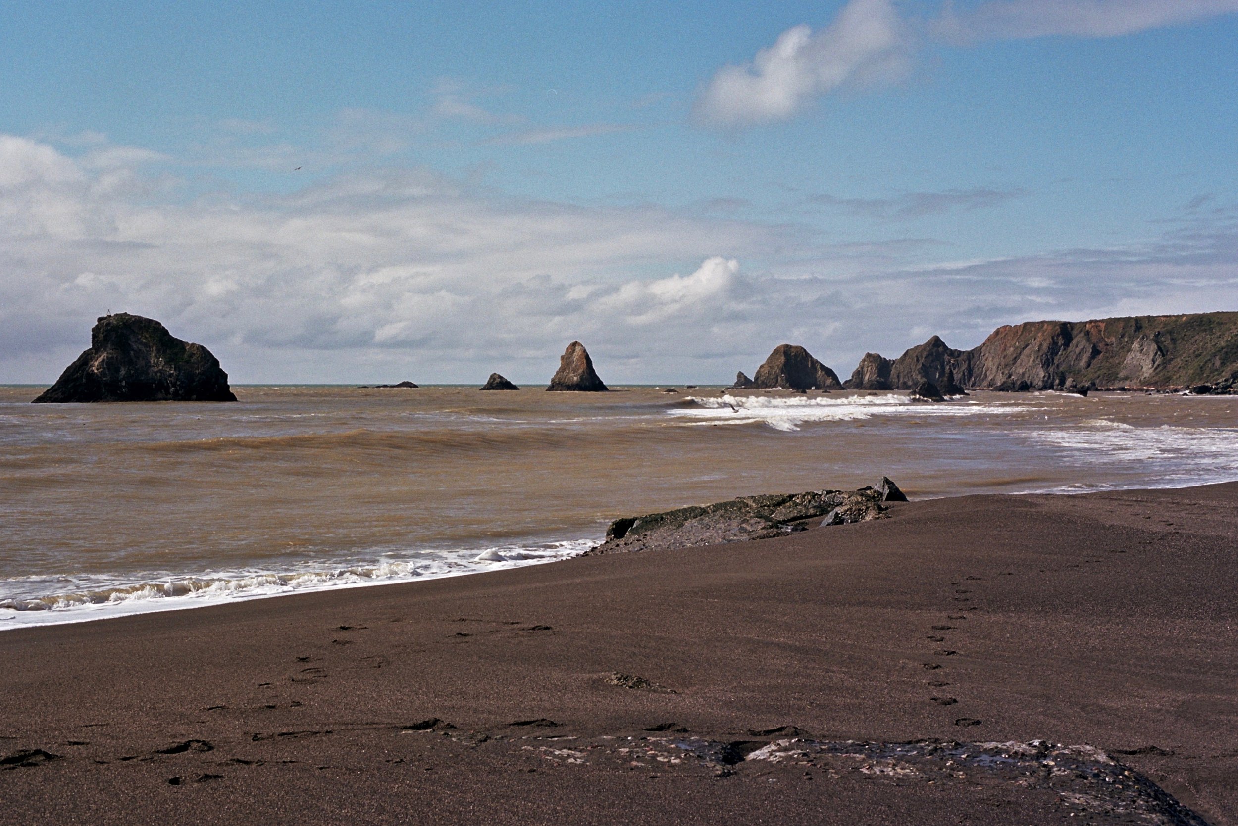Coffee-colored water pours from the Russian River into the Pacific near Jenner, CA