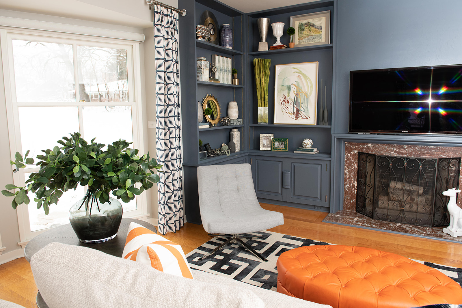 White paint of the windows, a light grey for the walls and a cool, dark blue for the built-ins made the space feel updated, modern and stylish.