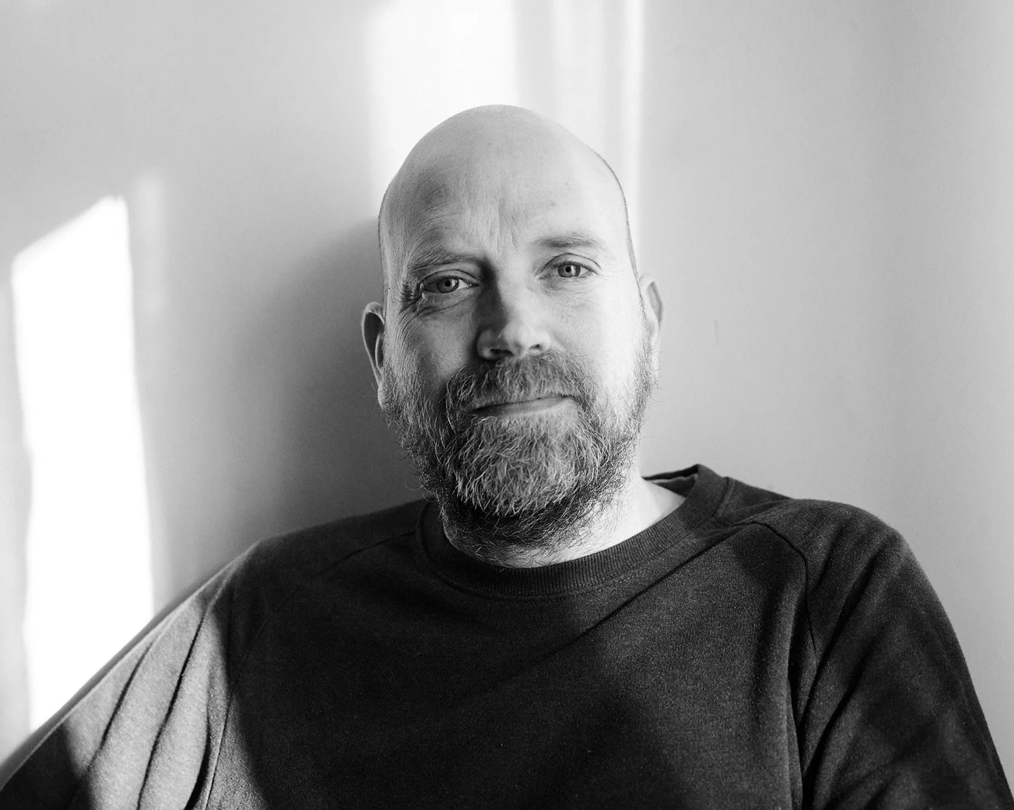 Porträt eines Digital Operators im natürlichen Licht, entspannt sitzend mit neutralem Gesichtsausdruck