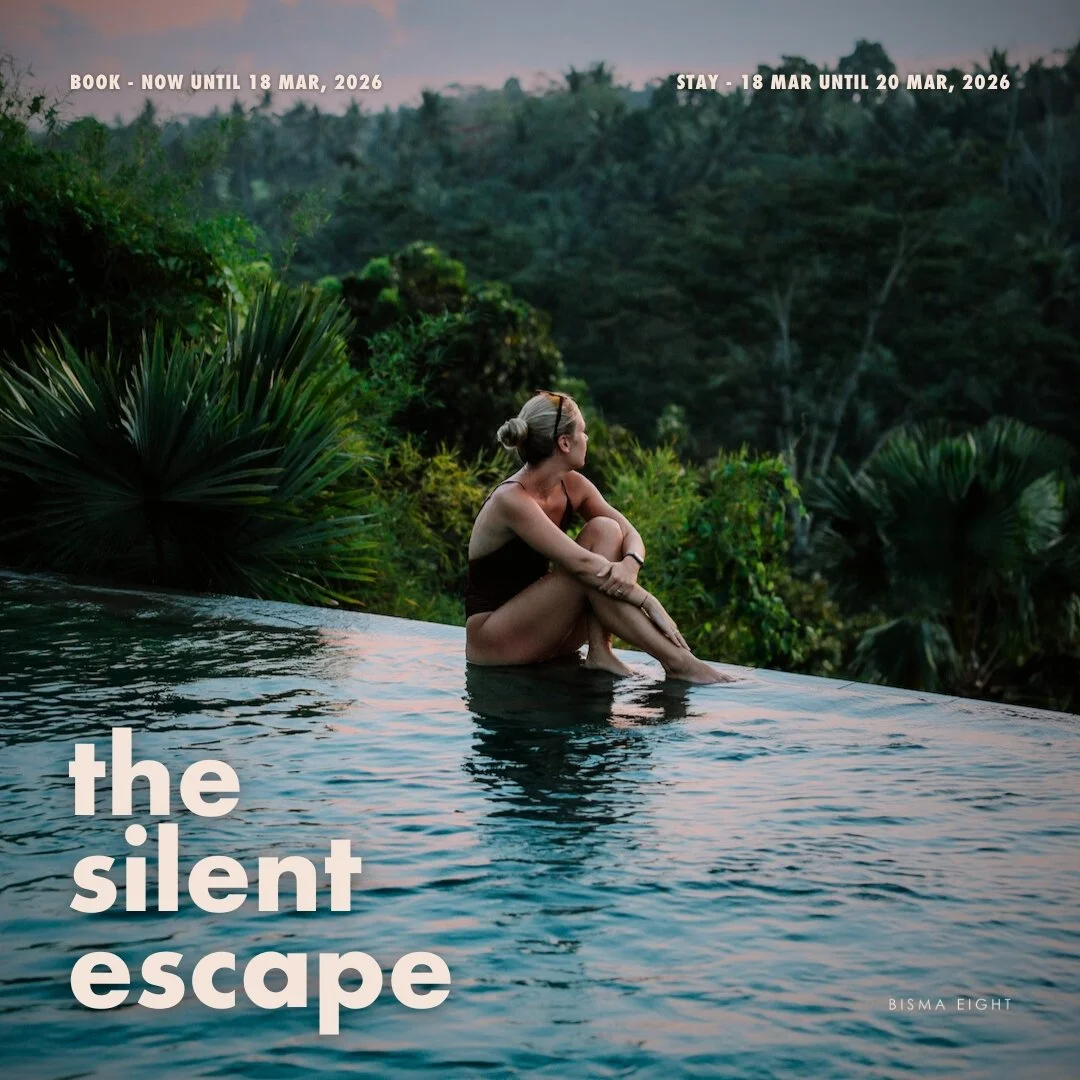 Woman sitting near the edge of an infinity pool at Ubud's best hotel overlooking lush green forest at sunset.