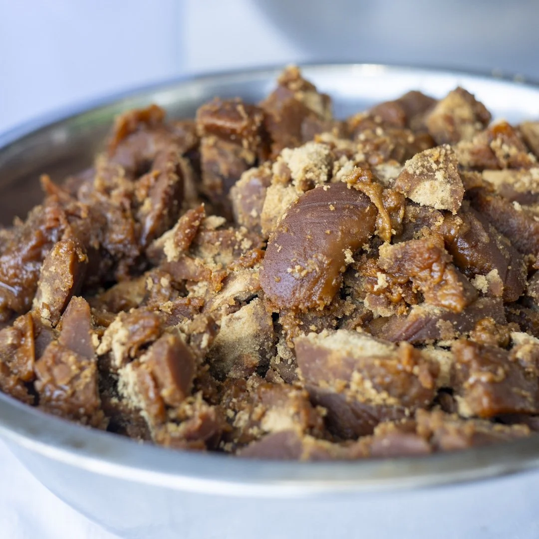 Close-up of a large bowl filled with chopped sweetened, spiced, and crumbly baked brown sugar and cinnamon fudge or toffee pieces.