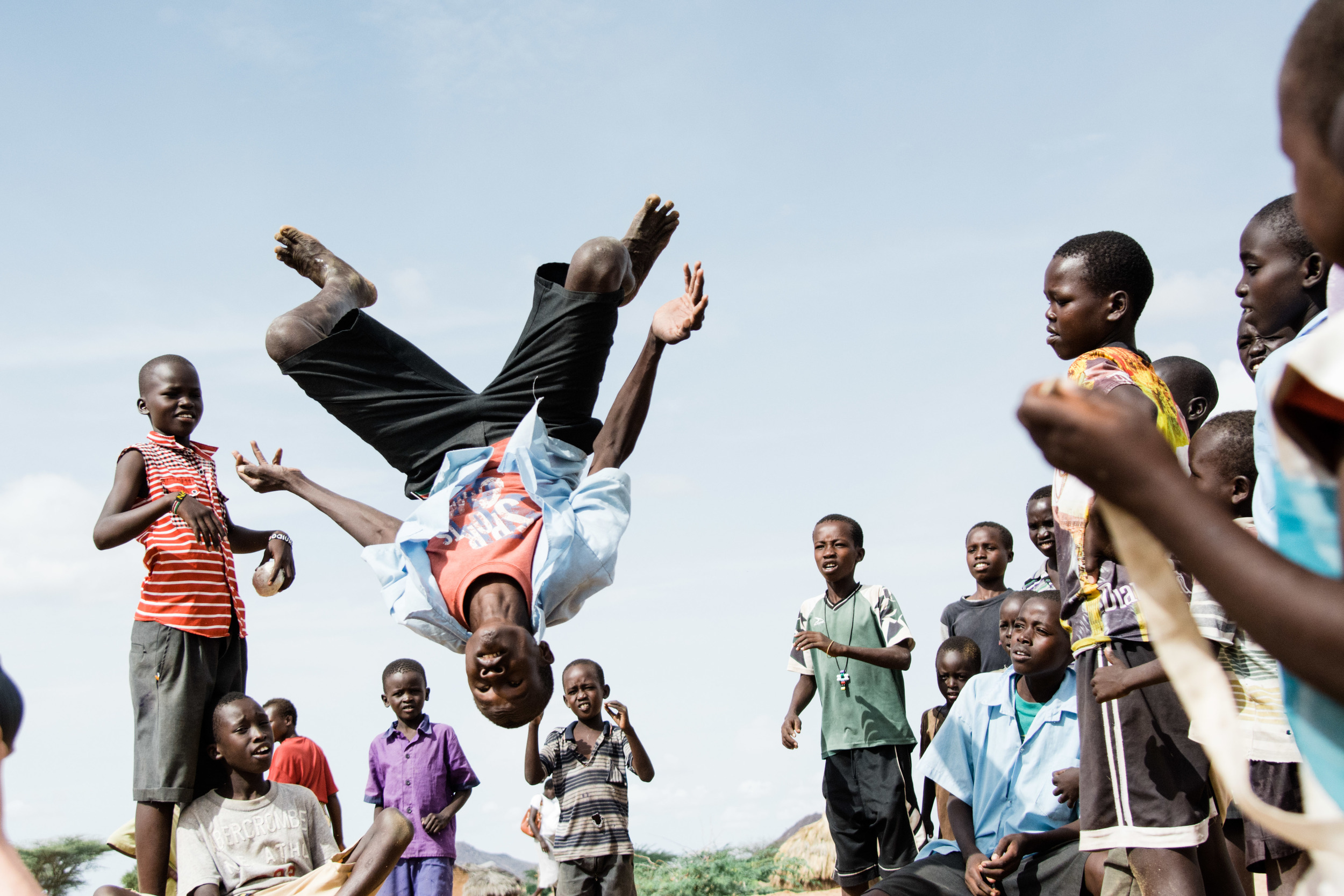 Children gathering to watch backflips in the courtyard