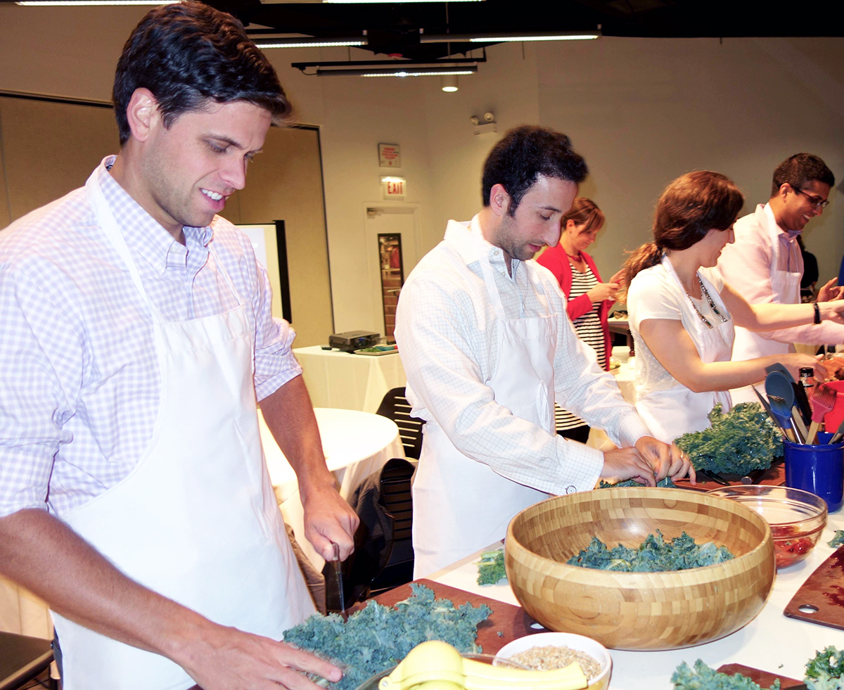 Caridology residents at Cardiology Cooks! chopping and massaging kale for kale salads.