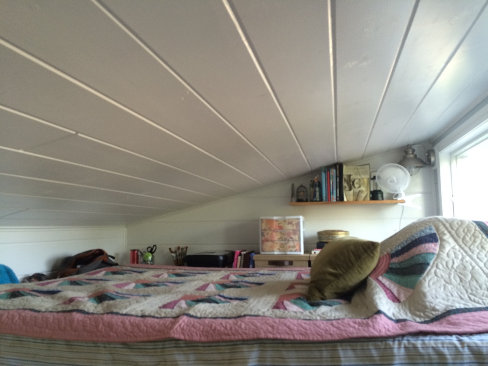  The sleeping loft. It holds a queen size bed and in the back along the wall we store out-of-season clothes, office supplies and stationary, books we are currently reading, extra blankets, and a small filing box. At the foot of the bed we can just sq