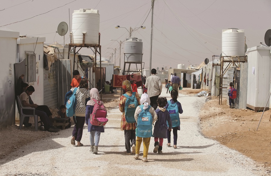 Children walk through the Zaatari refugee camp, where polio vaccination teams go door to door as part of the mass immunization campaign taking place throughout Syria and its bordering countries — Lebanon, Iraq, Israel, Jordan, and Turkey.