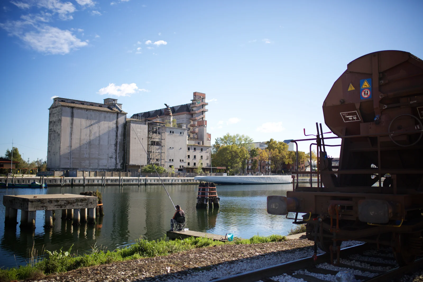 Il Canale Industriale Ovest. Nonostante i divieti e l’attività industriale/portuale ancora in corso, alcuni abitanti di Marghera non rinunciano a pescare in uno dei canali creati negli anni Trenta con la doppia funzione di scarico di materiali tossici residui dai processi industriali e trasporto merci. Il canale è stato messo in sicurezza ma non bonificato. Marghera, Ottobre 2014