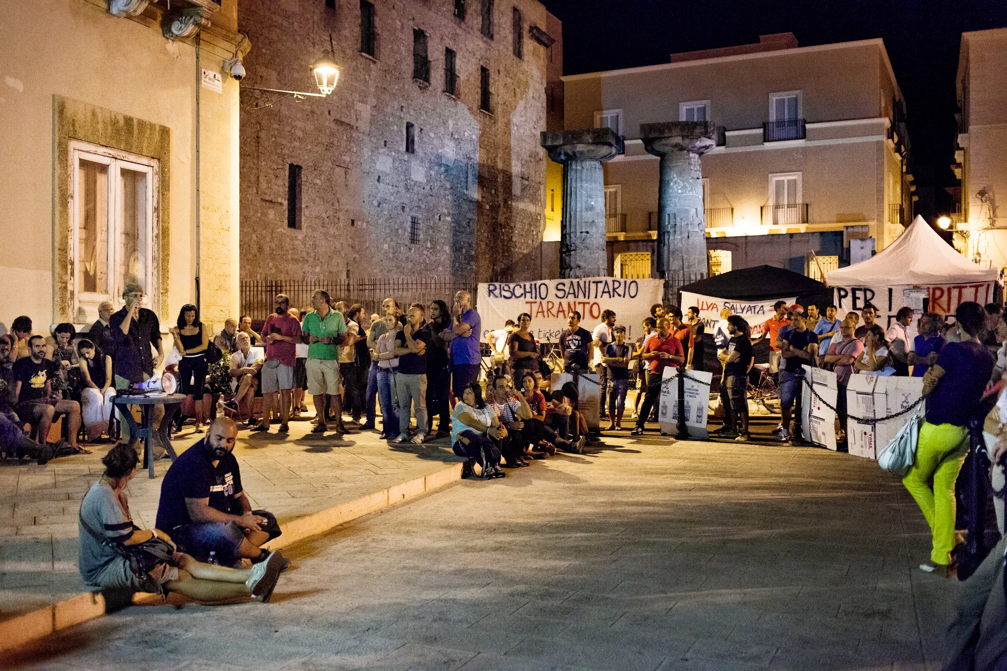 Taranto, Italia, 11 Settembre 2013. Un’assemblea durante il terzo giorno di presidio di protesta in piazza Castello, di fronte al Comune di Taranto. Il presidio, durato 26 giorni, era organizzato da associazioni e cittadini riuniti sotto il nome di “Cittadini #fuoridalcomune”: chiedevano una maggiore attenzione e partecipazione alle questioni ambientali da parte dell’istituzione locale.