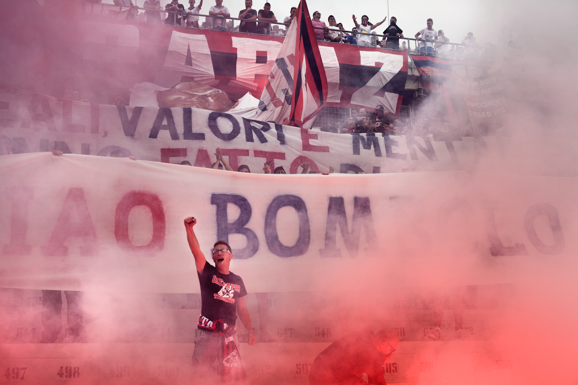  Taranto, Italia, 29 Settembre 2013. I tifosi della curva nord ricordano la scomparsa di un loro compagno con una coreografia di striscioni e fumogeni allo stadio Erasmo Iacovone di Taranto. Il Taranto Calcio è attualmente in serie D a seguito dell’e