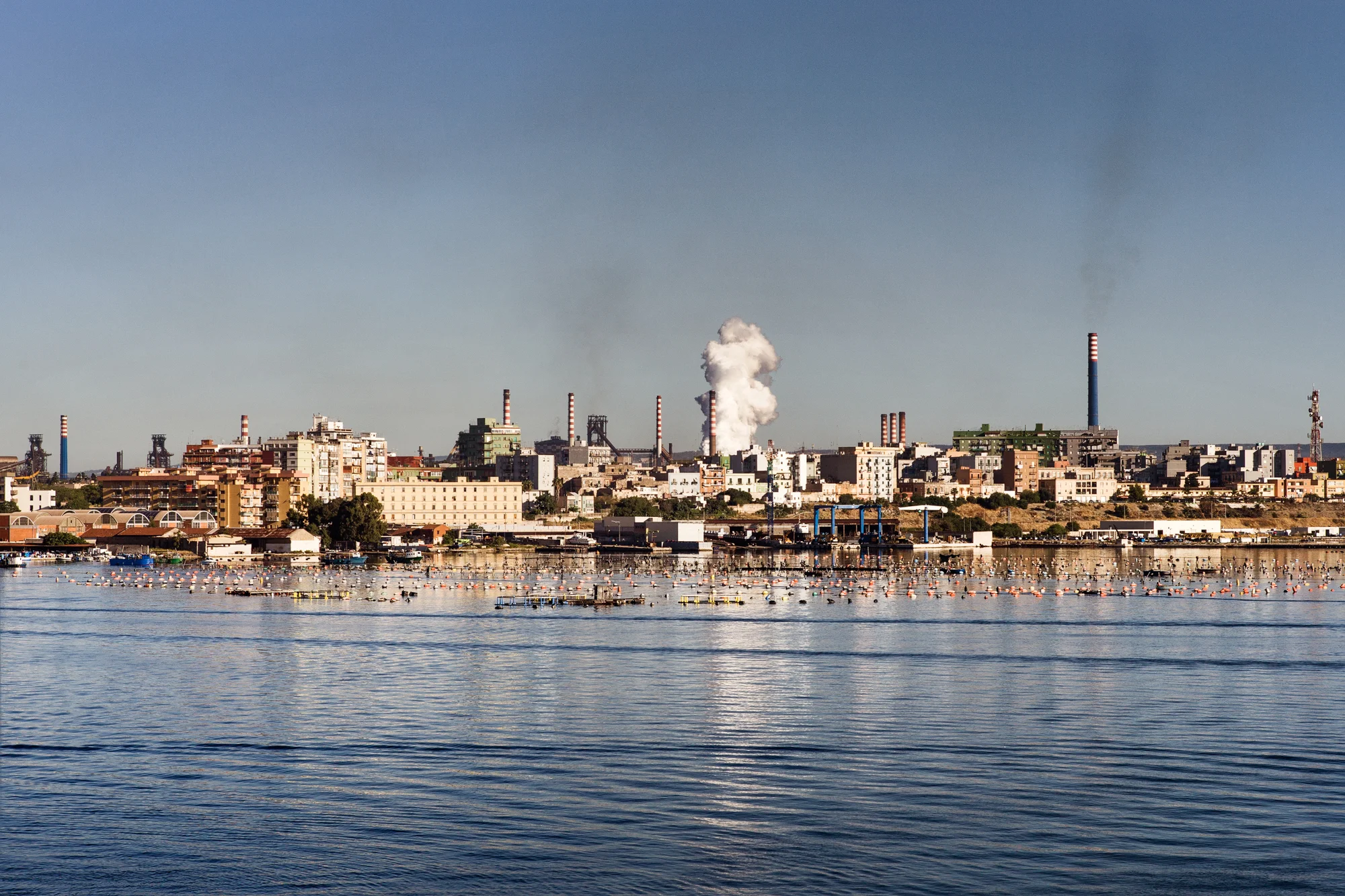 Taranto, Italia, 5 Settembre 2013. Fumi dall’Ilva scaturiti dal raffreddamento del coke con acqua marina, sono composti da polveri e vapore acqueo. Ogni giorno circa 15 fumate si liberano nell’aria senza essere convogliate. I lavori di ambientalizzazione previsti dall’Autorizzazione Integrata Ambientale rilasciata dal Ministero dell’Ambiente obbligano Ilva al rifacimento delle torri di raffreddamento del coke.