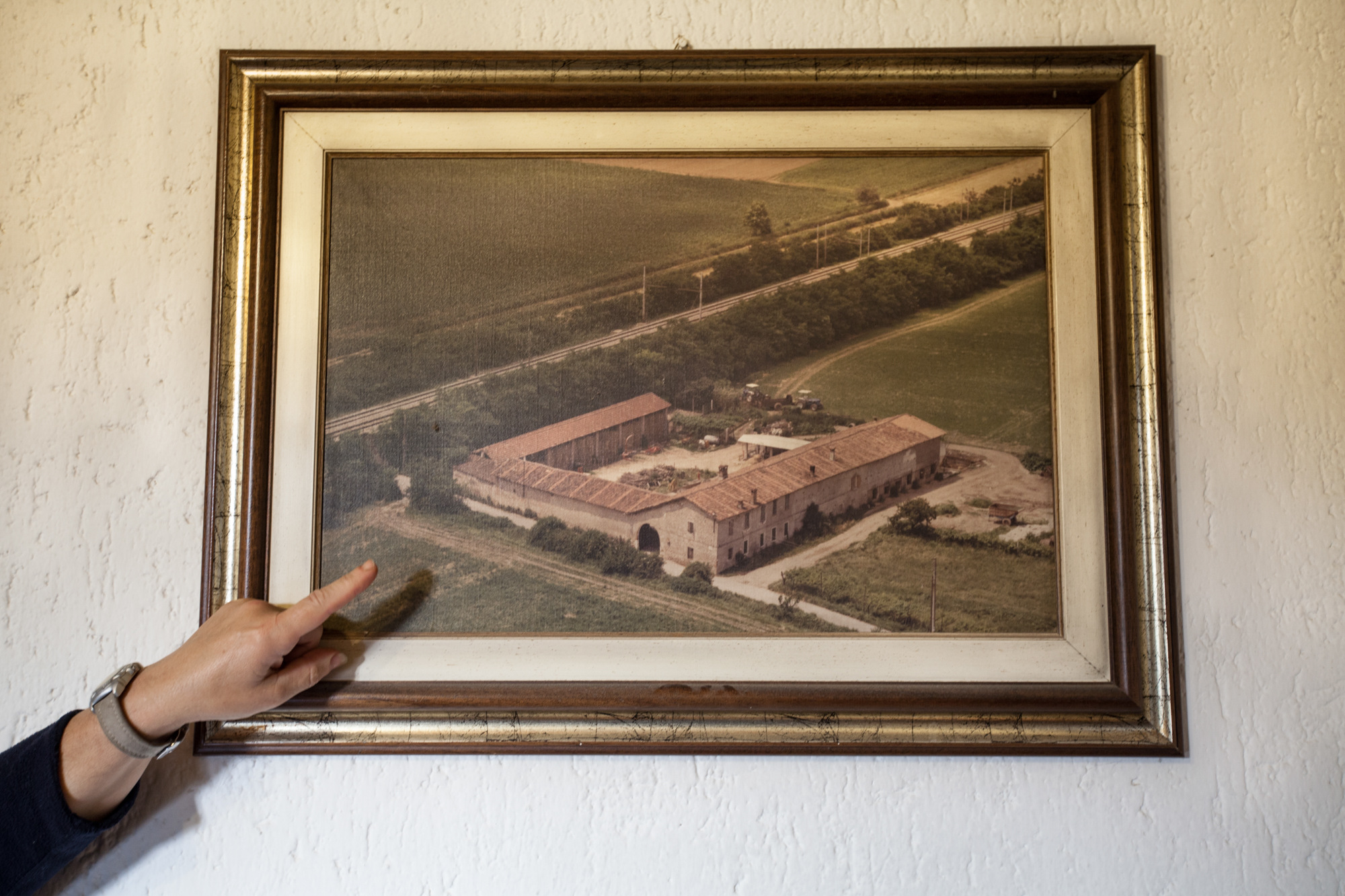  La moglie di un contadino mostra una vecchia foto aerea della propria cascina e dei campi circostanti.Brescia / Italia. Ottobre 2013 