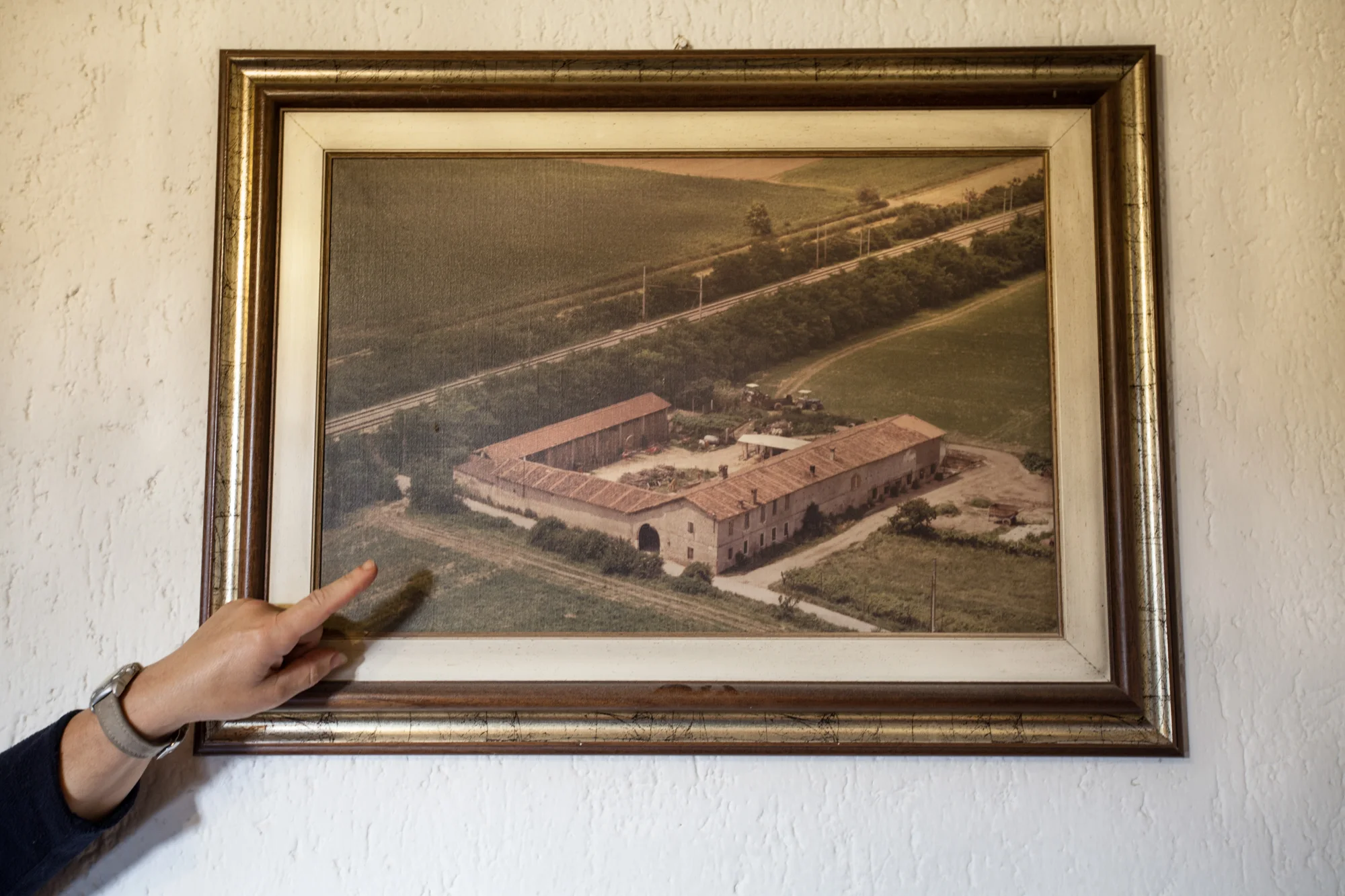 La moglie di un contadino mostra una vecchia foto aerea della propria cascina e dei campi circostanti.Brescia / Italia. Ottobre 2013