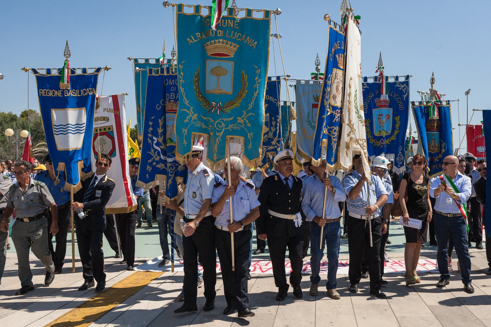 Stendardi comunali alla manifestazione contro le estrazioni petrolifere nel Mar Jonio, lungomare di Policoro (MT), 15 luglio 2015. Il corteo, organizzato dal presidente della regione Basilicata Marcello Pittella, ha avuto l’adesione dei presidenti della Regione Puglia e Calabria, dei sindaci dei paesi della zona e di alte cariche istituzionali. La partecipazione dei cittadini è stata scarsa e non hanno aderito le associazioni civiche No Triv Potenza, Mo’ Basta, Liberiamo la Basilicata, No Triv Jonio, contestando al presidente della regione Basilicata un atteggiamento ambiguo nella gestione dall’affaire petrolio. 
