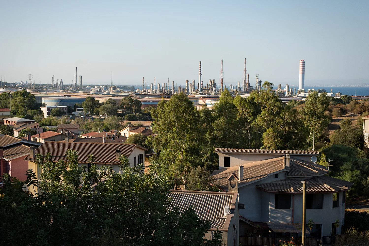 L’industria, in 50 anni di attività, è cresciuta sino a confondersi con le case del centro abitato. Sarroch (Cagliari), 2017.
