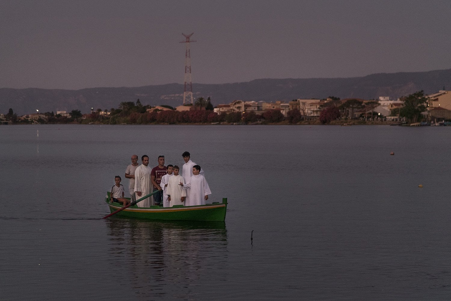  Sacerdote e chierichetti trasportati sulla feluca più antica del lago di Ganzirri per celebrare la messa dopo la Xiphias. Historica caccia al pesce spada, 29 luglio 2023. 