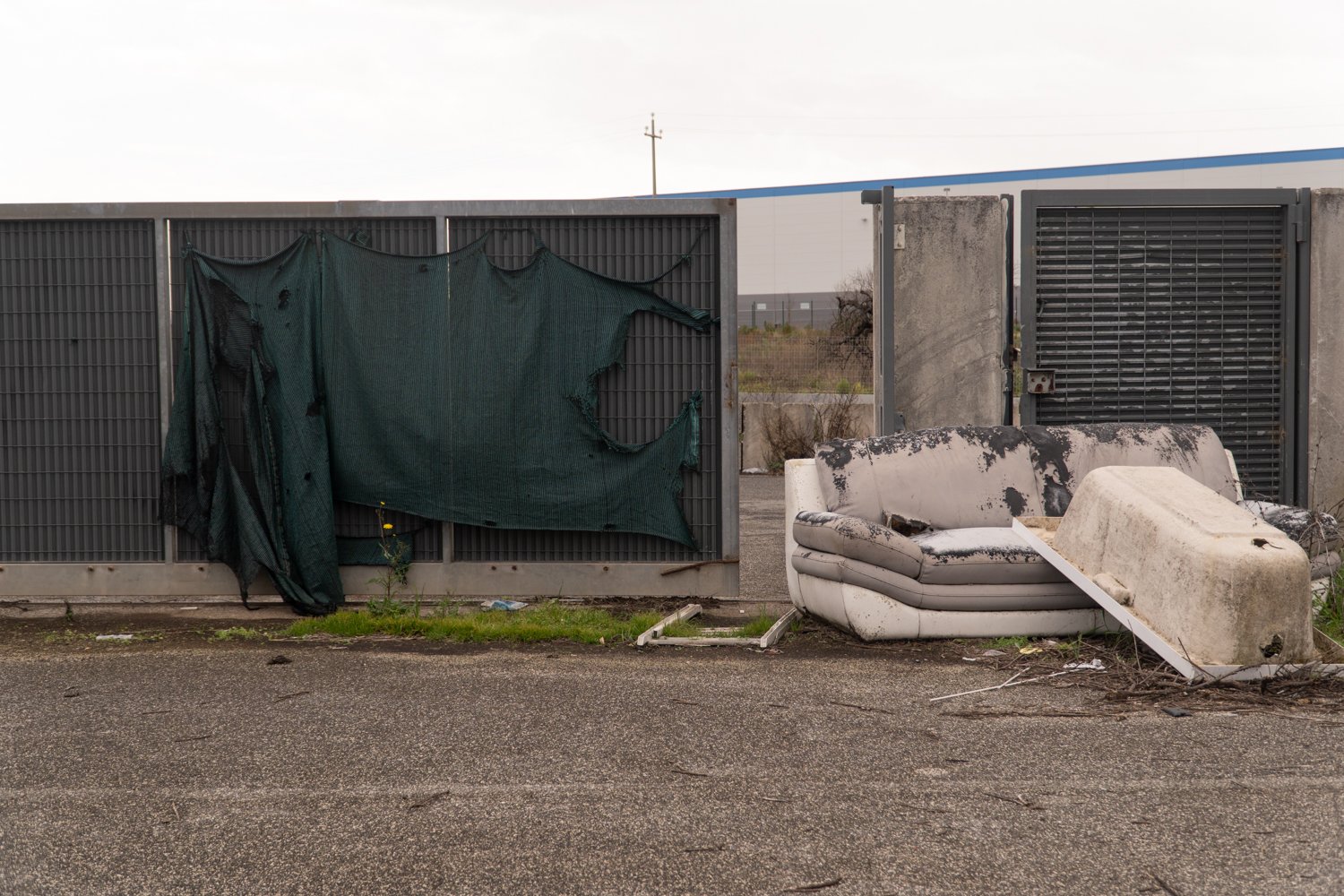  Ingresso dalla via Ardeatina al luogo dove sorgerà il termovalorizzatore, al momento in stato di abbandono, viene utilizzato come discarica a cielo aperto. Sullo sfondo il centro logistico di Amazon dietro a cui si trova l’azienda agricola Ceglia. S