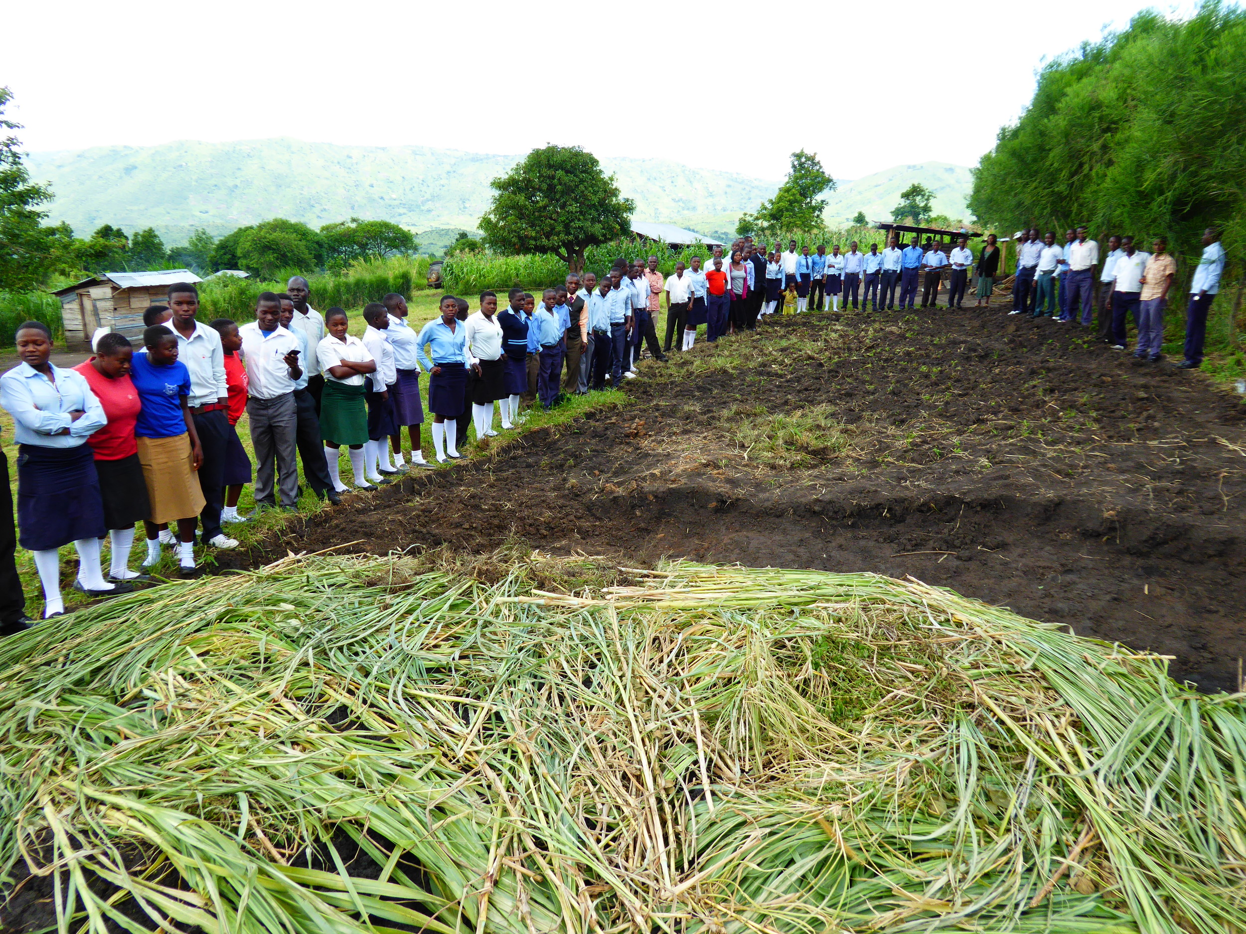 Students standing around land where permanent classrooms will be built