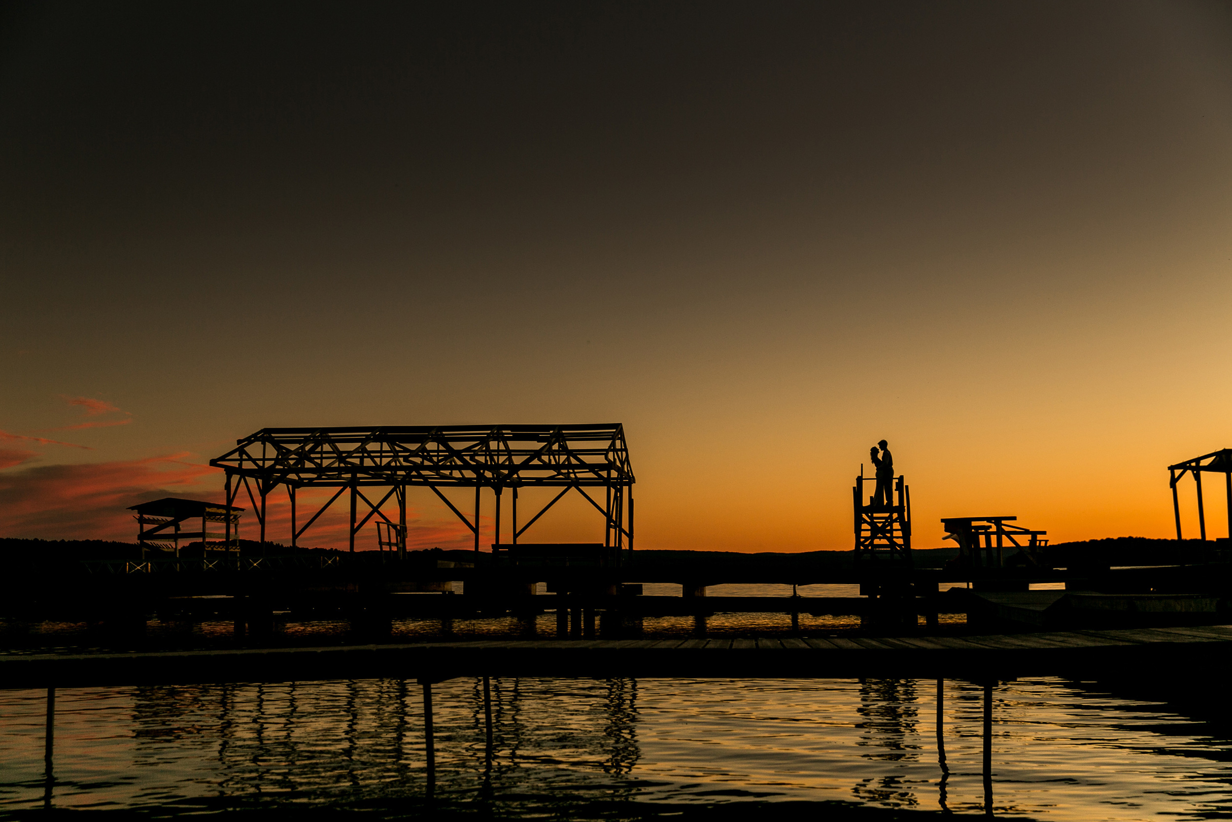 Bride and groom silhouette portrait during sunset on a lakeside dock (Copy)