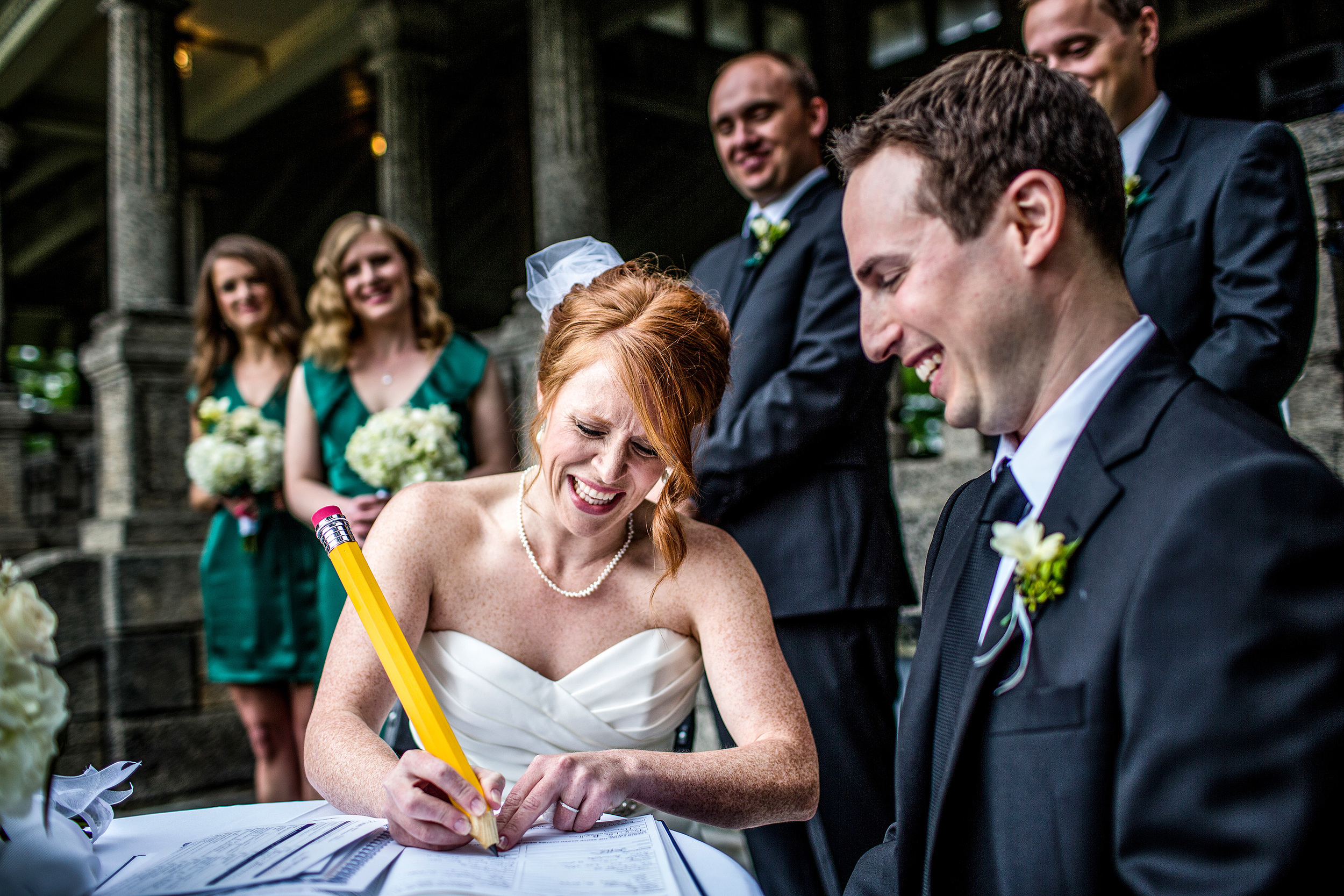 bride signs wedding license with big pencil during a ceremony at the rockcliffe park pavilion ottawa