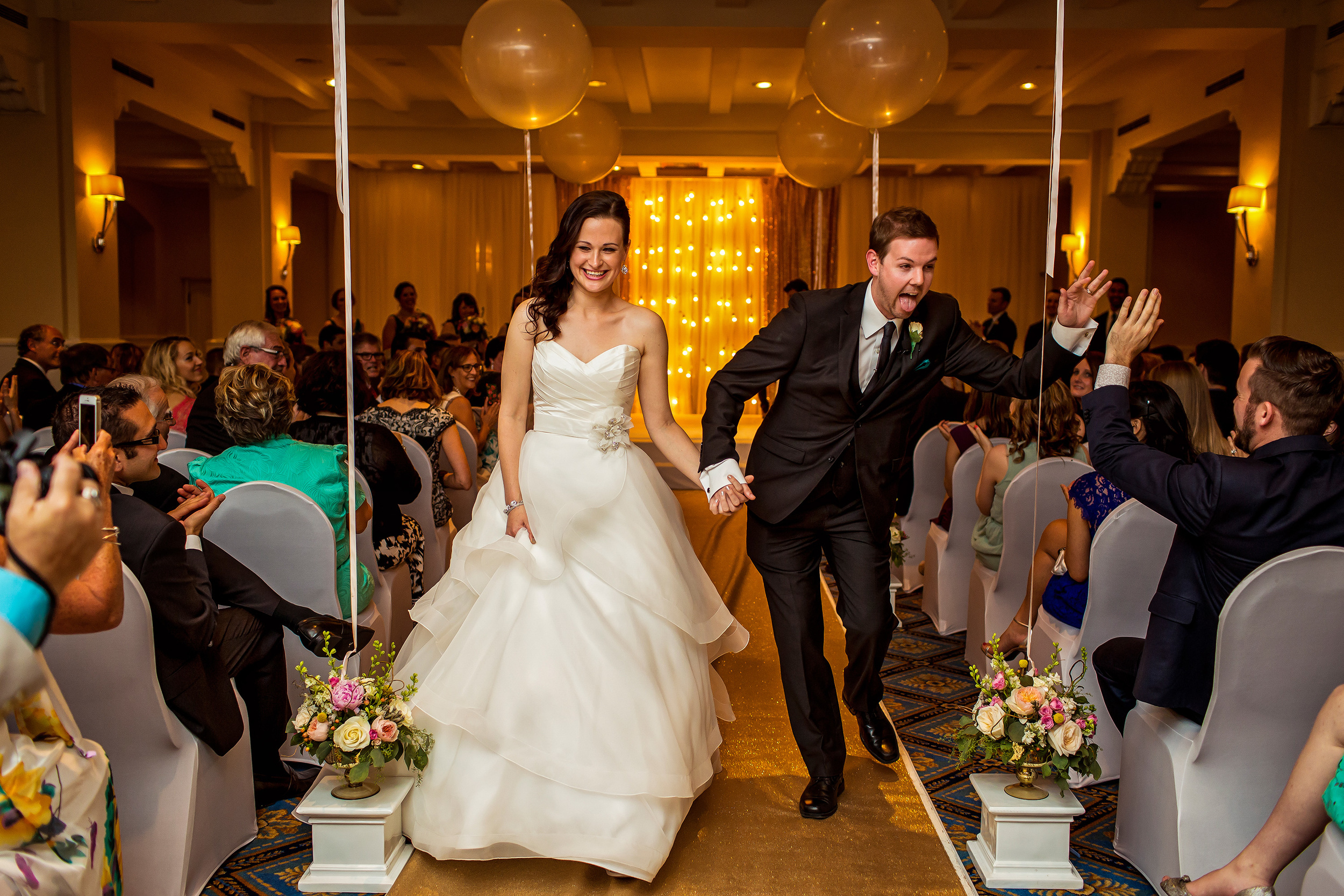 groom gives guest a high five he leaves wedding ceremony with his new wife at the chateau laurier canadian room