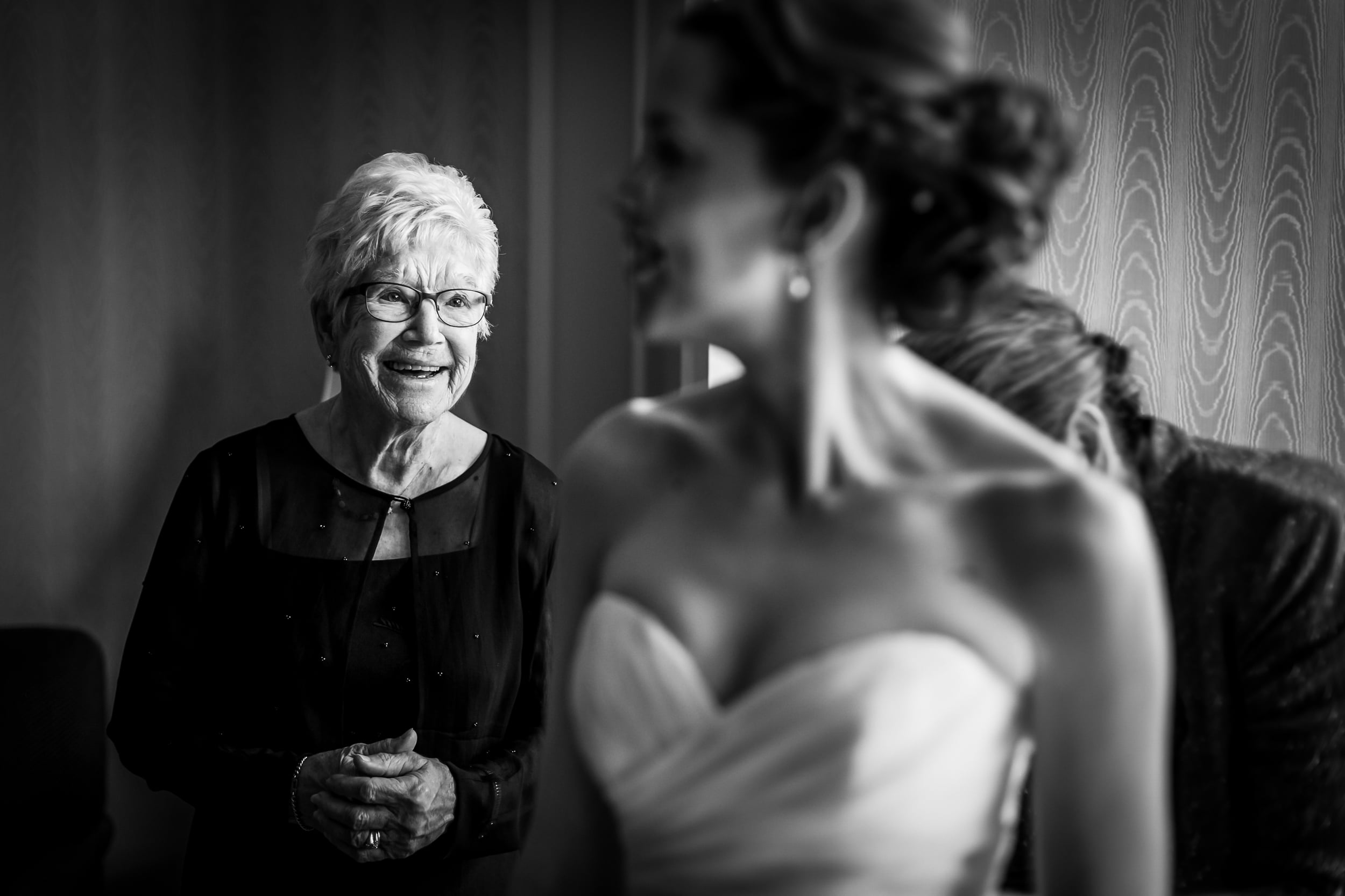 grandmother watching her grandaughter get into her wedding dress (Copy)