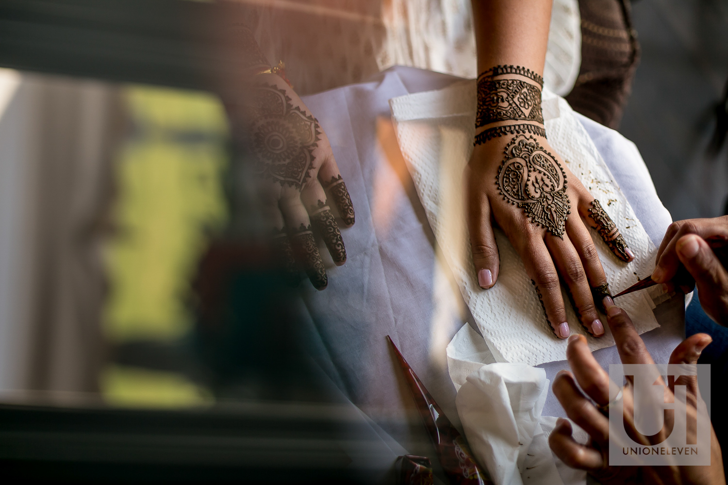  henna being applied to an indian brides hands 