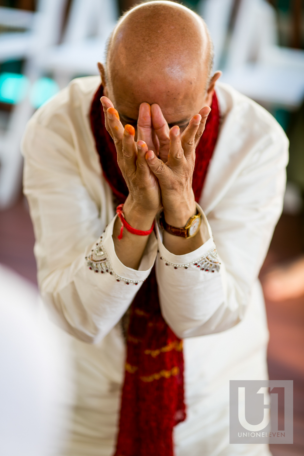  grooms father praying at a mendhi ceremony    