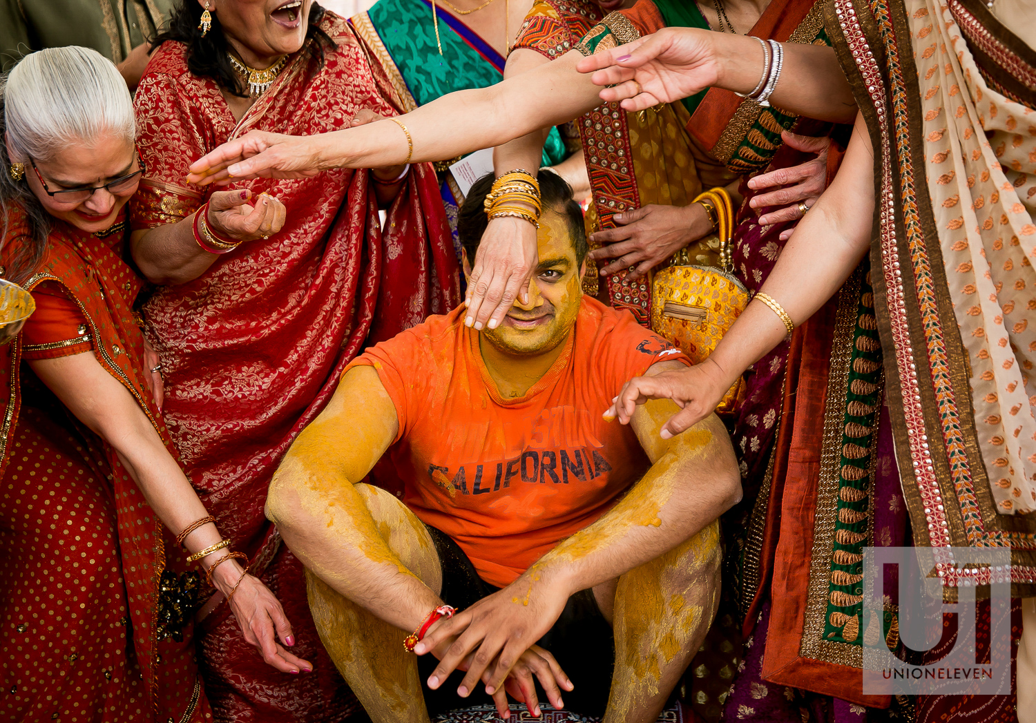  Pithi spice being rubbed all over an indian grooms face at his mendhi party 