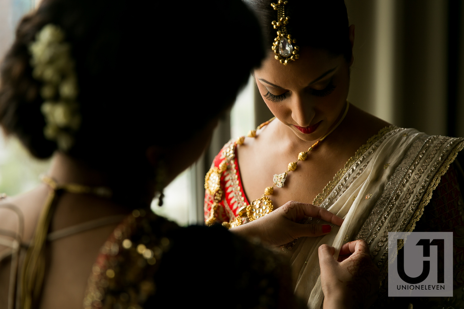 indian bride putting on her wedding dress