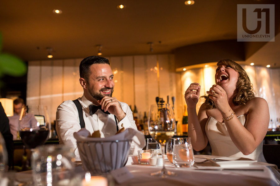 bride-and-groom-laughing-reaction-to-speech-during-wedding-reception-at-eighteen-restaurant-in-ottawa