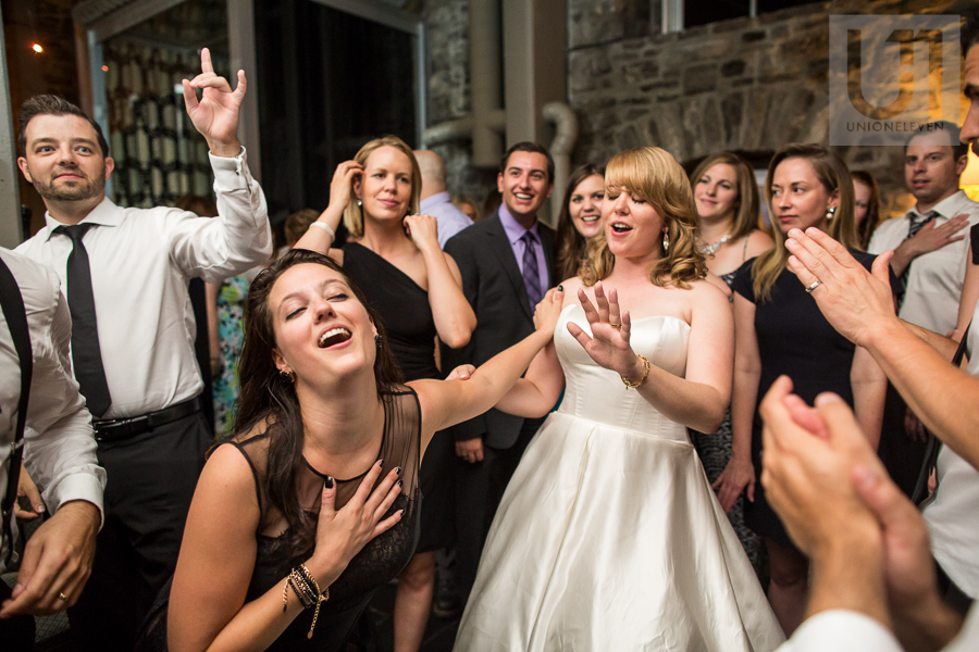 female-guest-fanning-herself-and-pushing-away-bride-while-dancing-during-wedding-reception-at-eighteen-restaurant-in-ottawa