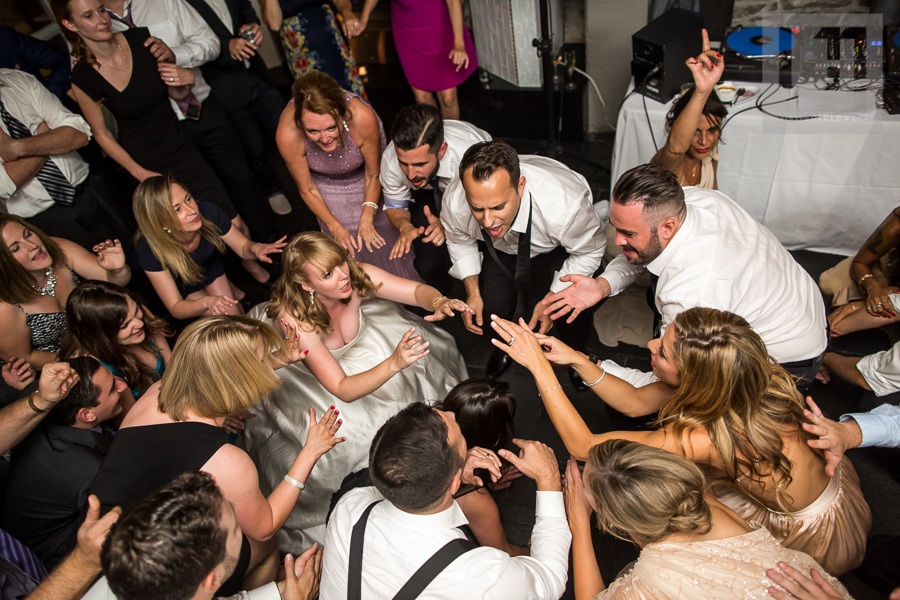 bride-groom-and-their-guests-getting-low-on-the-dance-floor-during-wedding-reception-at-eighteen-restaurant-in-ottawa