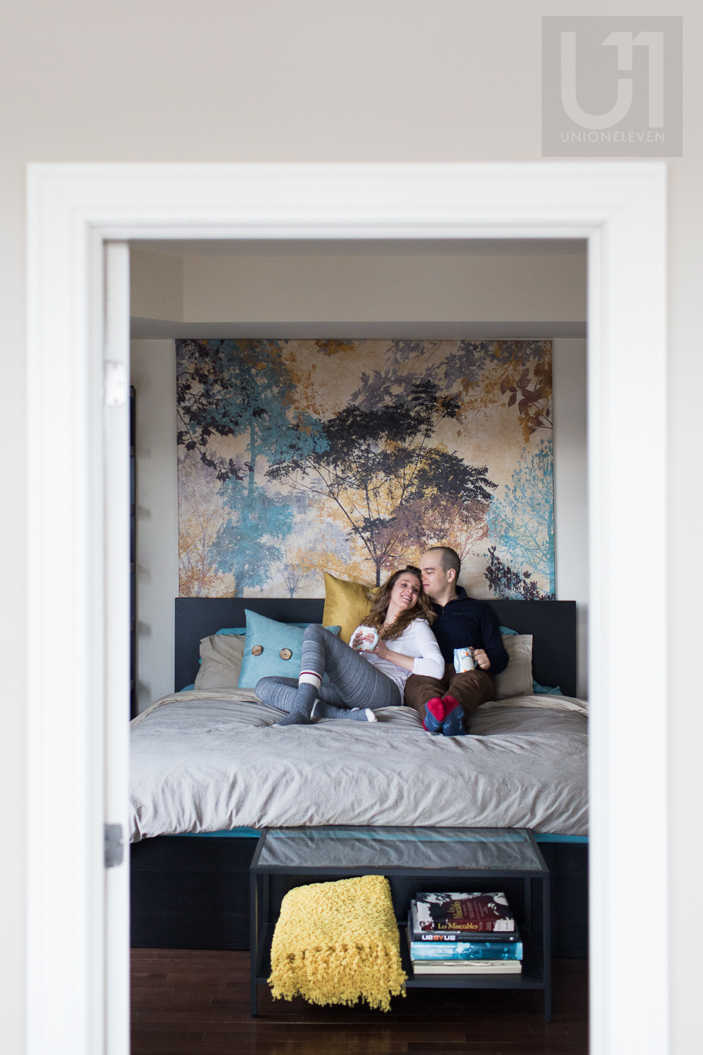 couple-snuggling-on-bed-through-doorframe